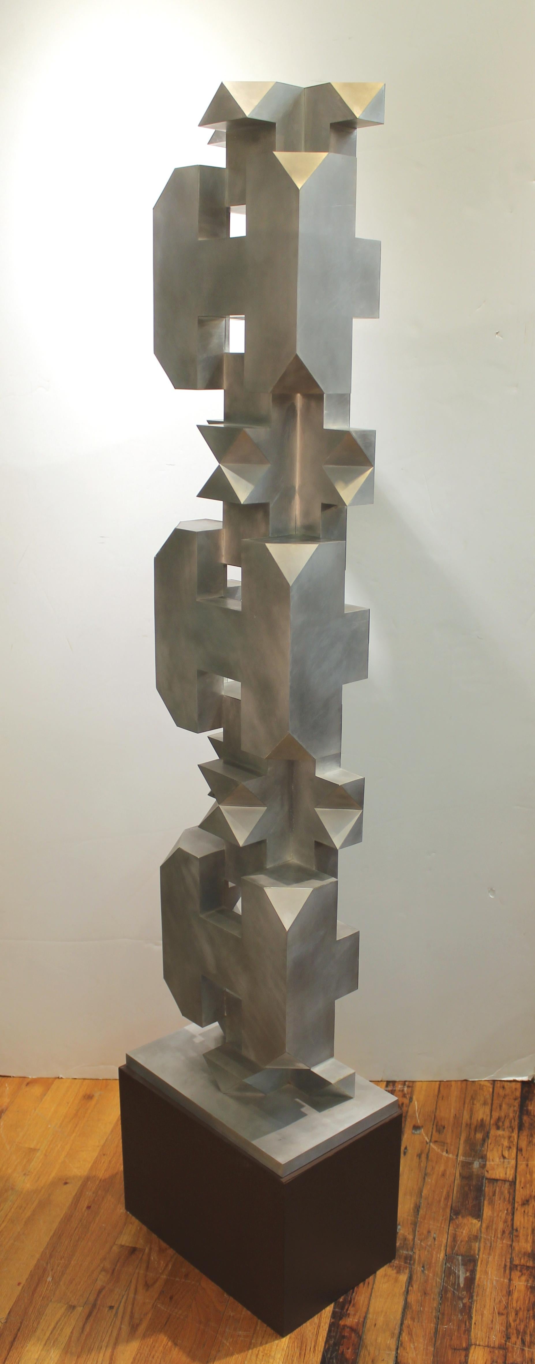 Isaac Kahn geometric TOTEM in brushed metal over composite on painted base. The sculpture is marked 