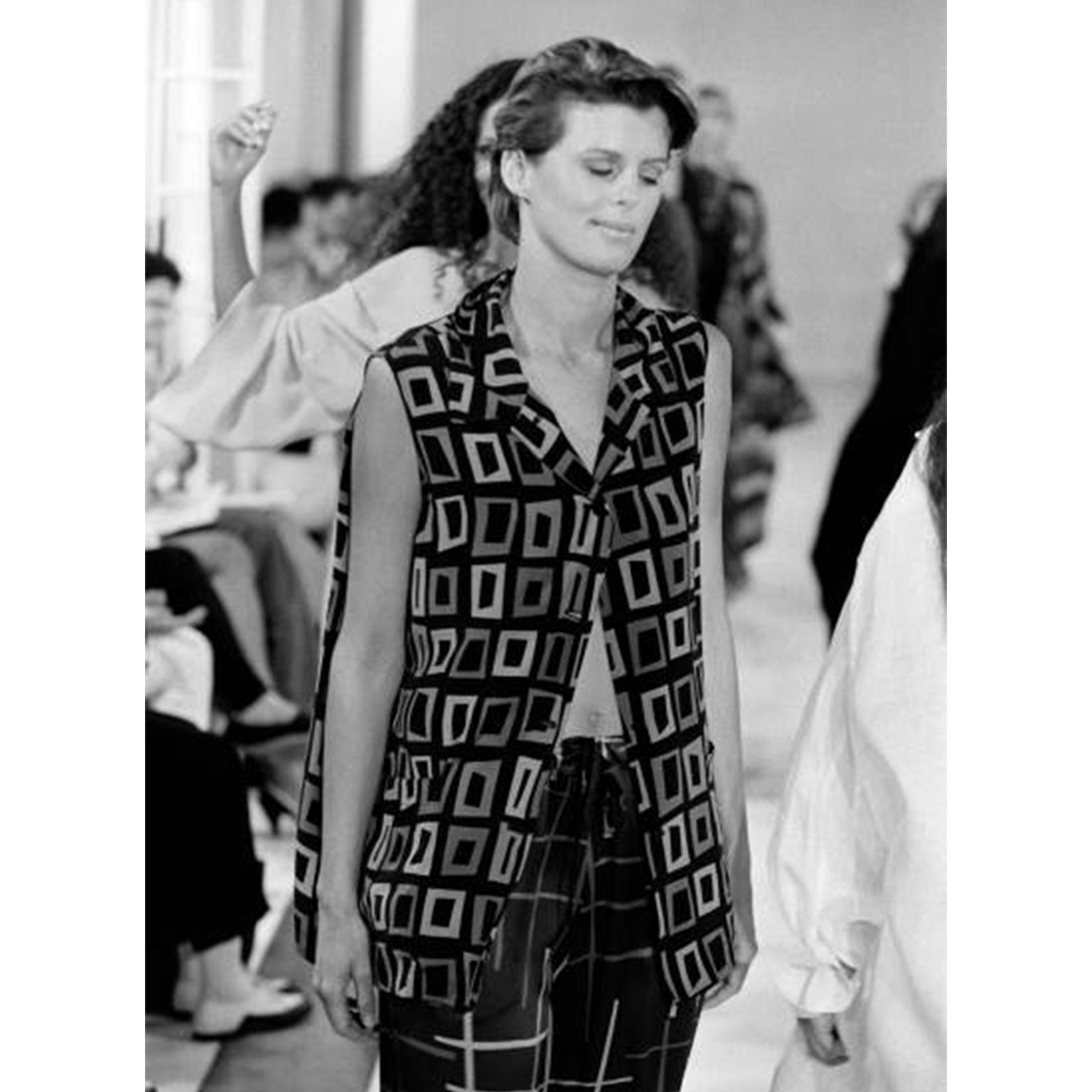 This Isaac Mizrahi sleeveless silk top is from the Mizrahi Resort 1994 collection. This lovely blouse is in an abstract square print in shades of black, purple, blue and turquoise and it buttons down the front. There are two patch pockets and a