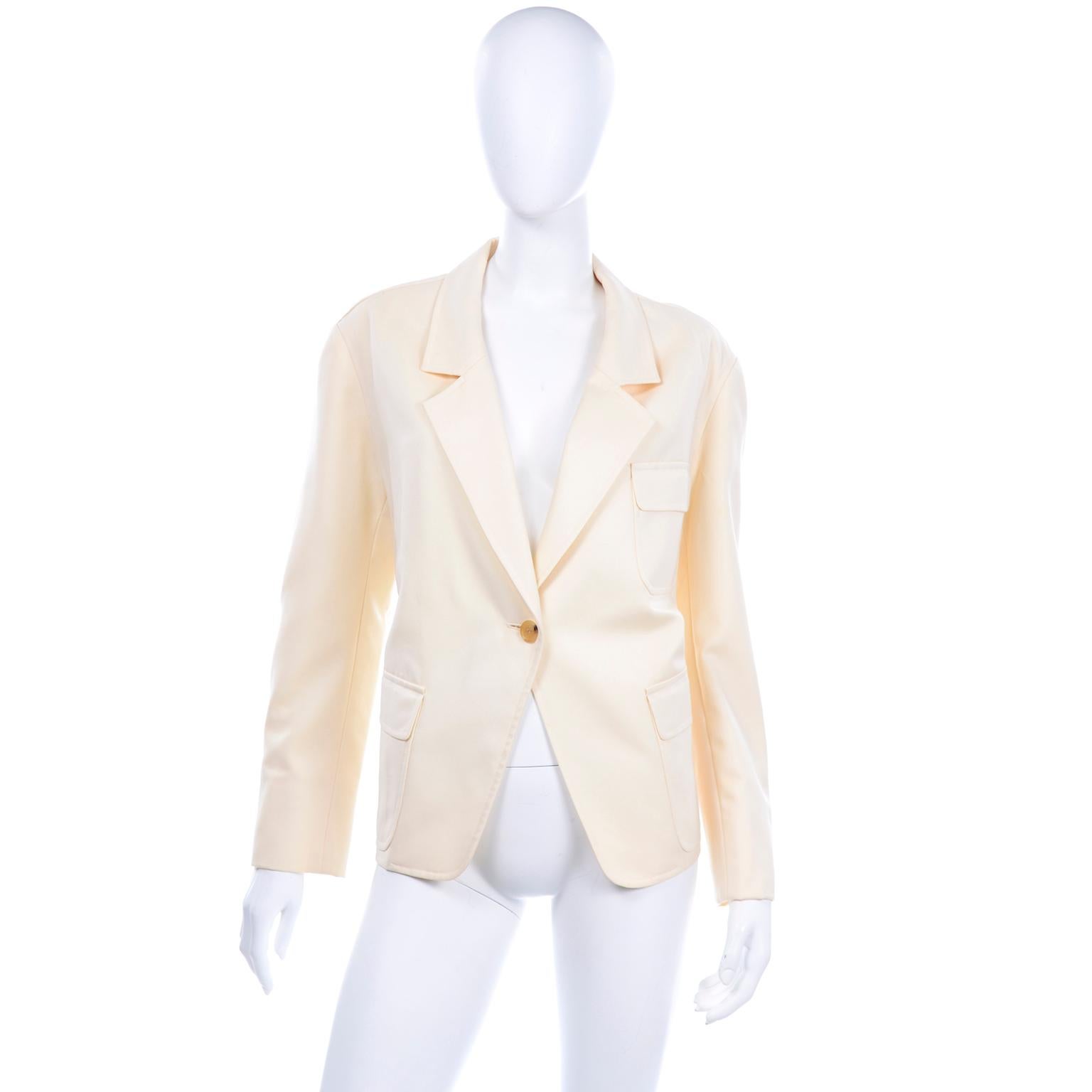 Vintage Isaac Mizrahi 100% Pure New Wool cream blazer. This boxy jacket closes with one light tortoise button and has flap front pockets, a breast pocket, and shoulder pads. The blazer is fully lined with small buttons on the sleeves.Labeled size