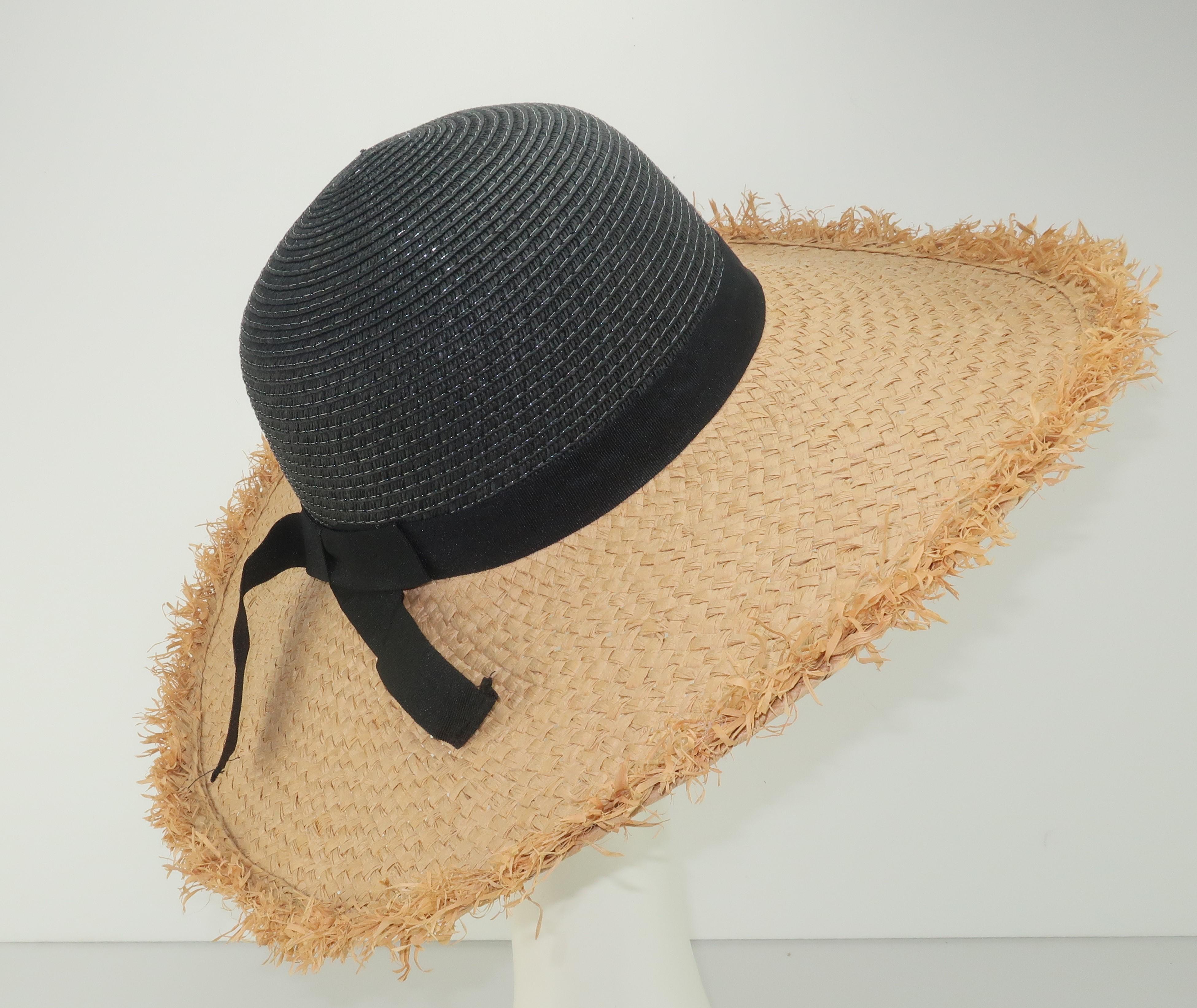 Isaac Mizrahi paper straw hat in a combination of natural and black with a black grosgrain ribbon band.  The fringed edges to the brim lends the hat a vintage 'tiki' look perfect for beach wear.  
CONDITION
Good previously owned condition.  No