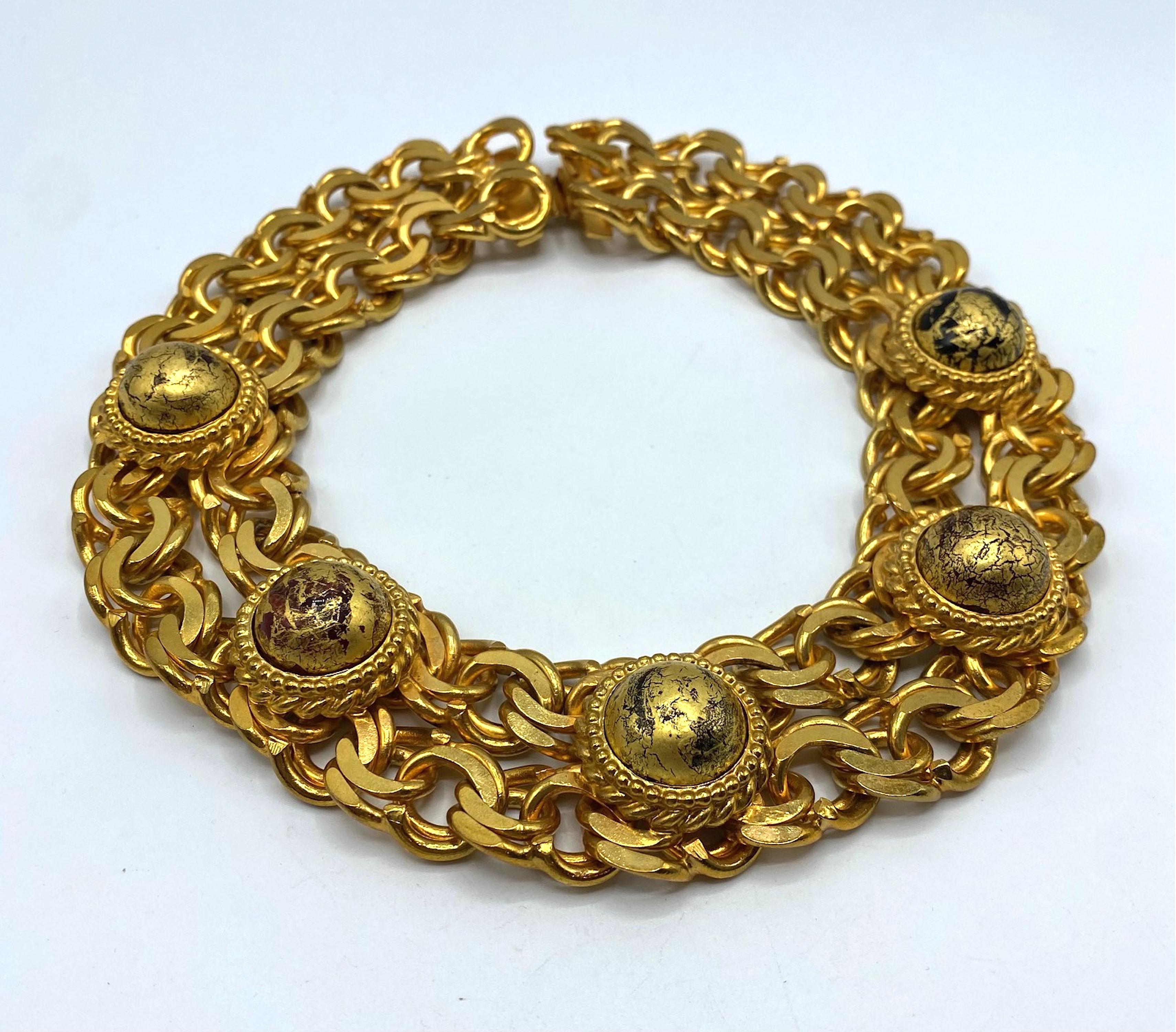 A spectacular Isabel Canovas necklace in gilt metal with art glass cabochons from the 1980s. The necklace is a wide collar style in a rich semi satin and semi shiny 18K gold plate. There are two strands of double curb link chains soldered together