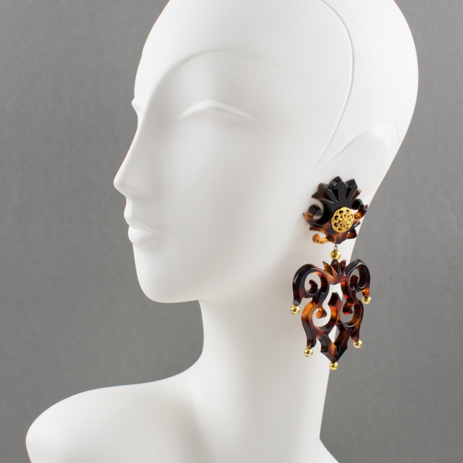Isabel Canovas Paris designed these outstanding resin or Lucite clip-on earrings. The massive dangling chandelier shape boasts a baroque carving and see-thru in tortoiseshell color complemented with gilt metal beads and ornament. The pieces are
