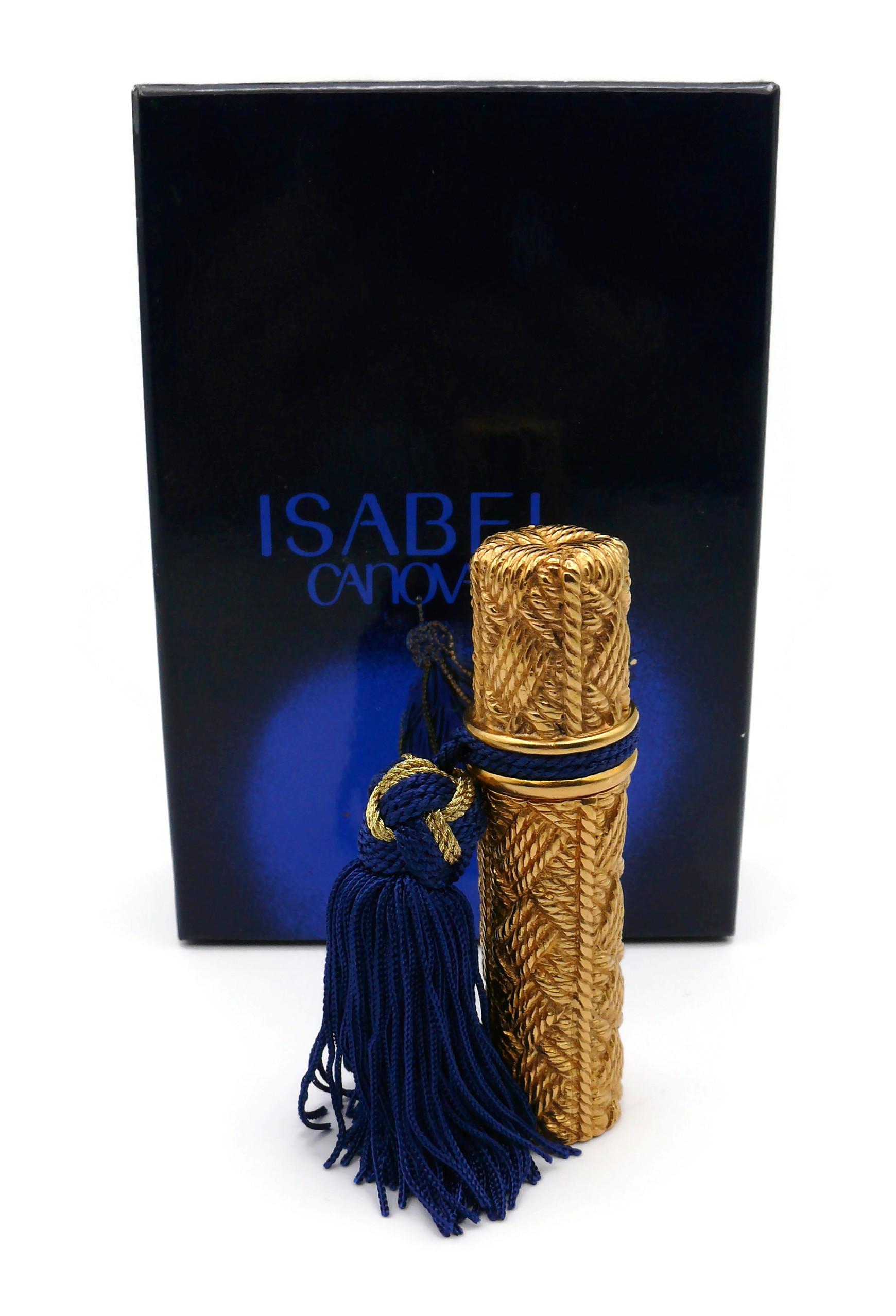 ISABEL CANOVAS Parfum by ROBERT GOOSSENS vintage atomizer featuring a gold tone metal wickerwork design embellished with an attached blue and gold tassel.

Embossed ISABEL CANOVAS PARIS Made in France.

IMPORTANT INFORMATION
- The ISABEL CANOVAS