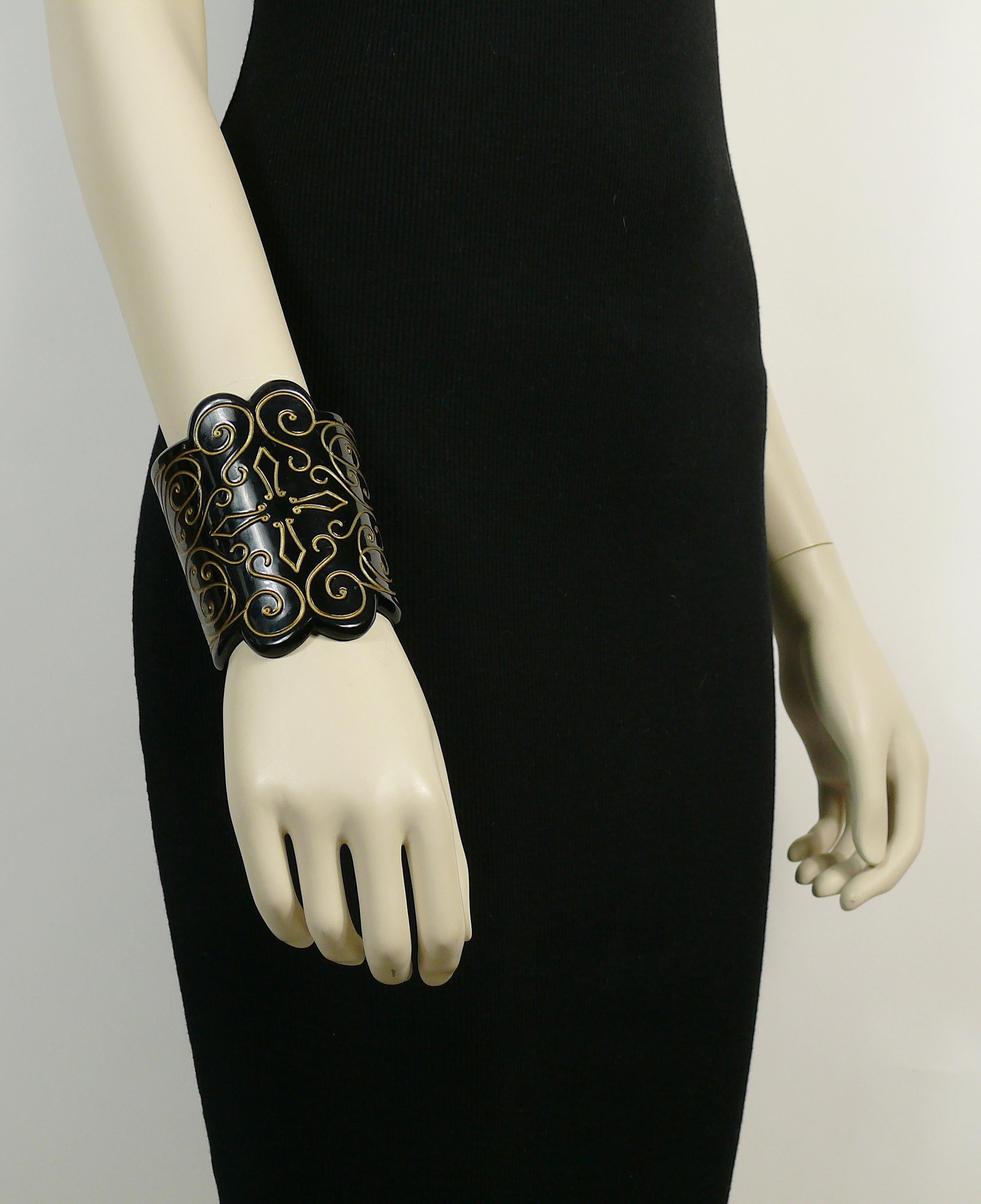 ISABEL CANOVAS vintage black resin cuff bracelet embellished with gold toned arabesques and cross.

From ISABEL CANOVAS Russian Collection.

Embossed ISABEL CANOVAS.

Indicative measurements : inner measurements approx. 6.4 cm x 6 cm (2.52 inches x