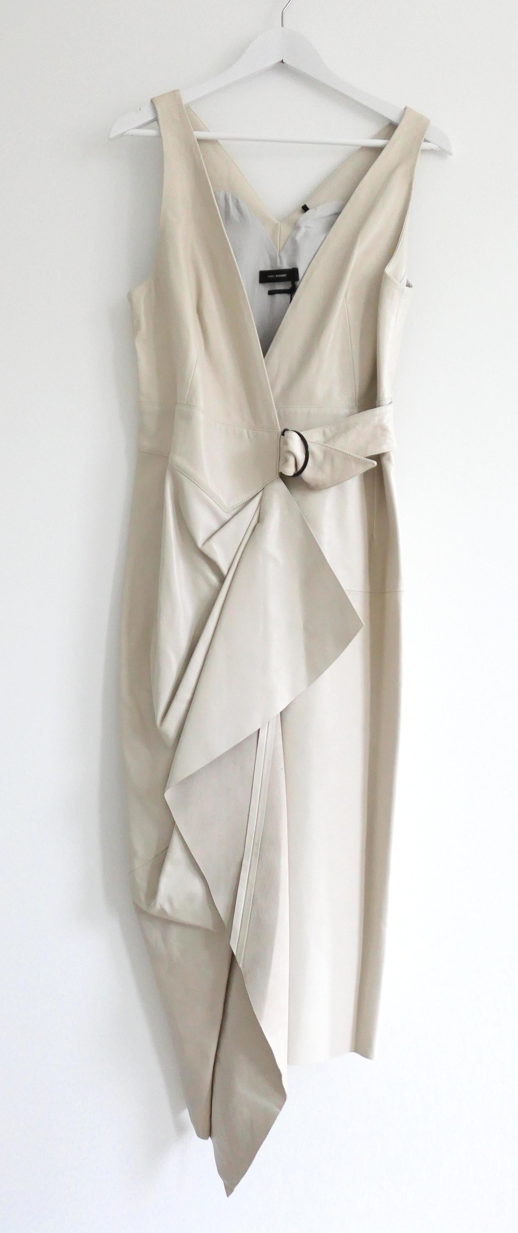 Gorgeous Isabel Marant Fanelia leather dress. Bought for £2795 and new with tag. Made from supple greyish ecru leather, it has a super sharp wrap cut with folded detailing, asymmetric hem and buckle hip strap. Has concealed snap fastenings to waist