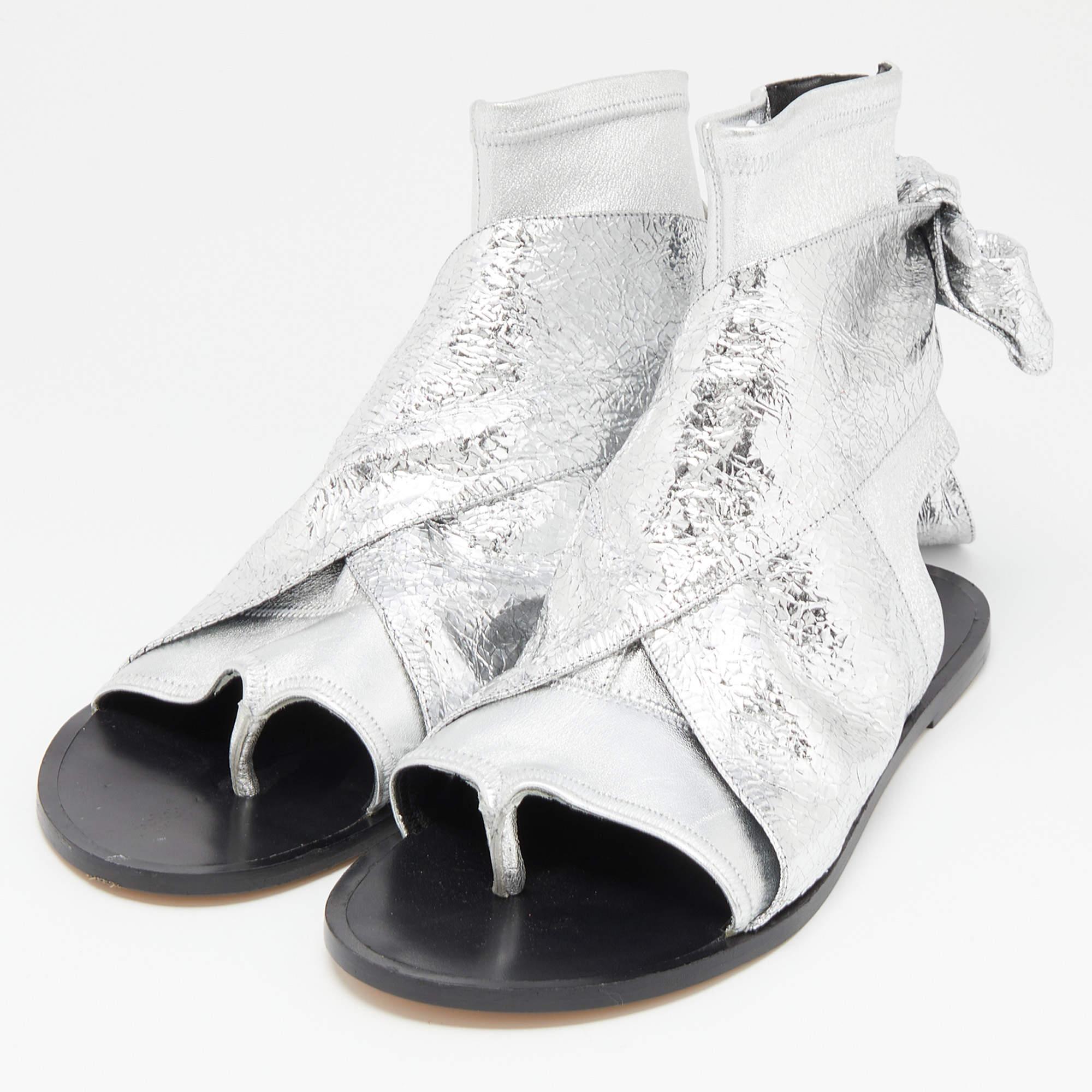 The Isabel Marant sandals are stylish and comfortable footwear. Made with silver leather, they feature a gladiator design with multiple straps and a flat sole. These sandals offer a chic and trendy look while providing a relaxed fit for everyday