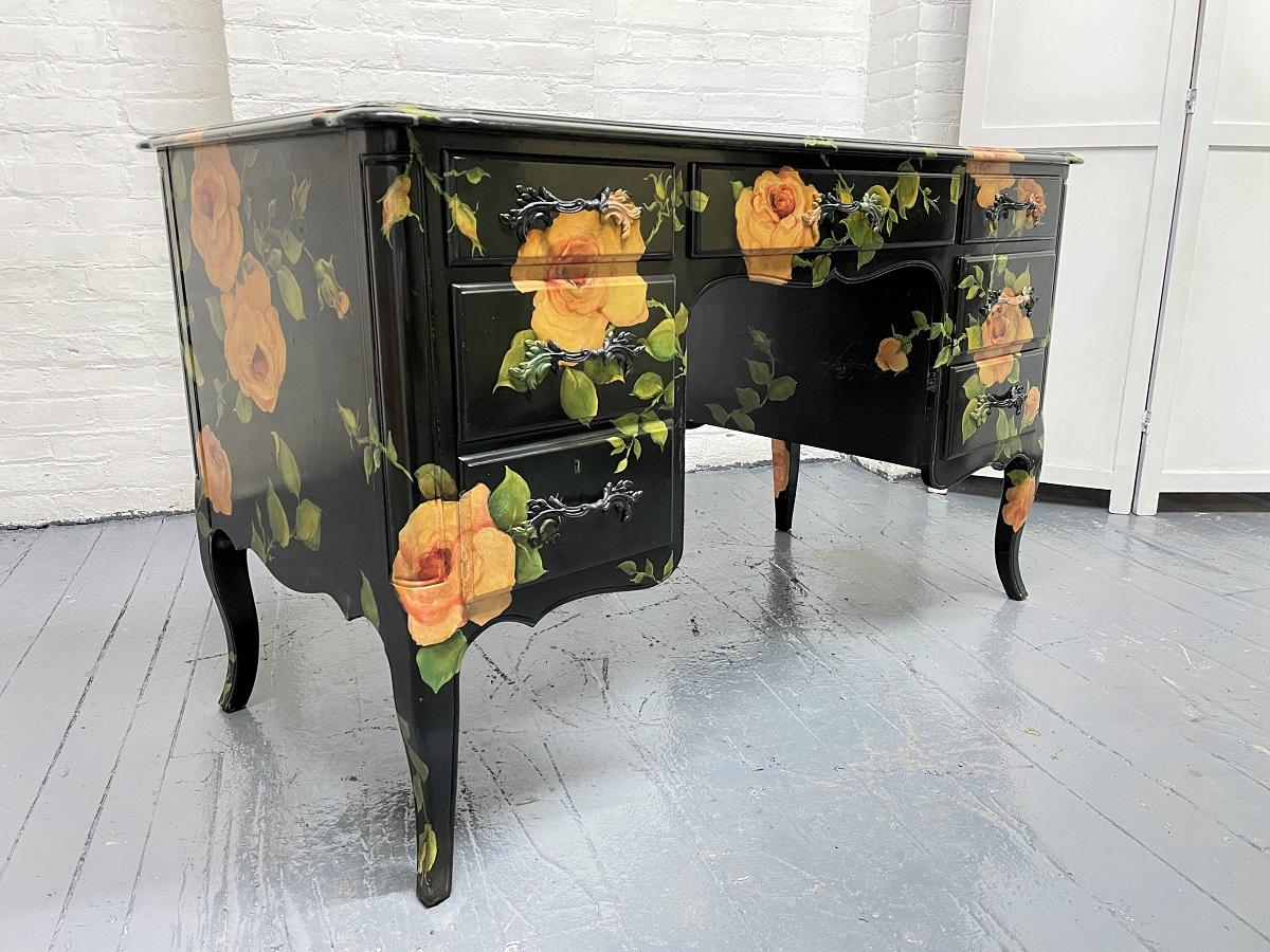 Isabel O'Neil (1908-1981) hand painted kneehole desk. The desk is a Louis XIV style and was hand-painted in 1986. 
The desk is black lacquered with hand-painted flowers. The desk has three pull-out drawers on one side, a pull-out drawer to the