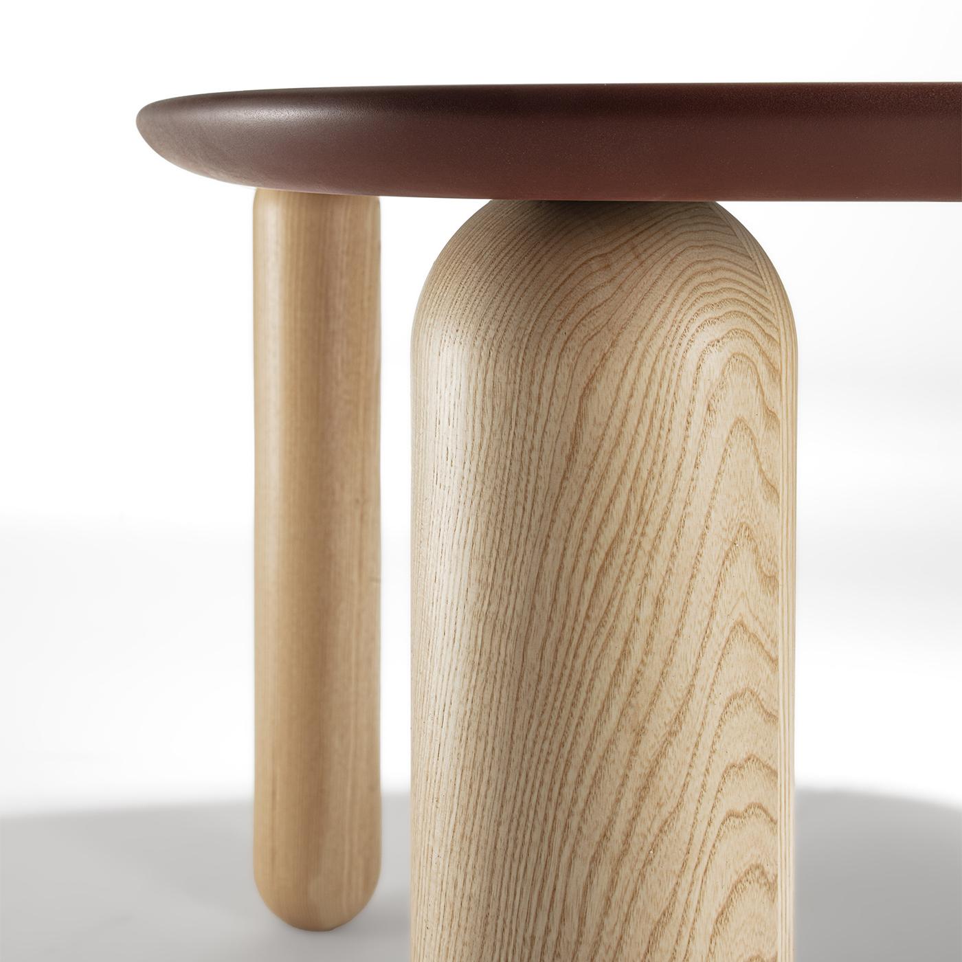 This table features a classic four-leg turned wood base, available in elegant ash. Its top is crafted from scratch-resistant lacquered wood, ensuring durability and a sleek finish. This design seamlessly blends traditional craftsmanship with modern