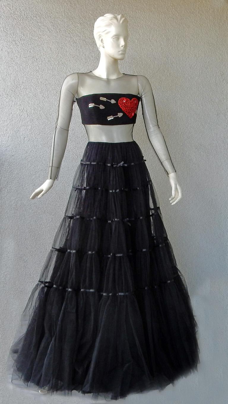 A unique and exciting gown by Isabel Sanchis, known for her imaginative evening wear.  Fashioned peek-a-boo black net bodice adorned with embroidered beaded silver arrows and large red heart encrusted with beadwork and stones.    Full (three) 3