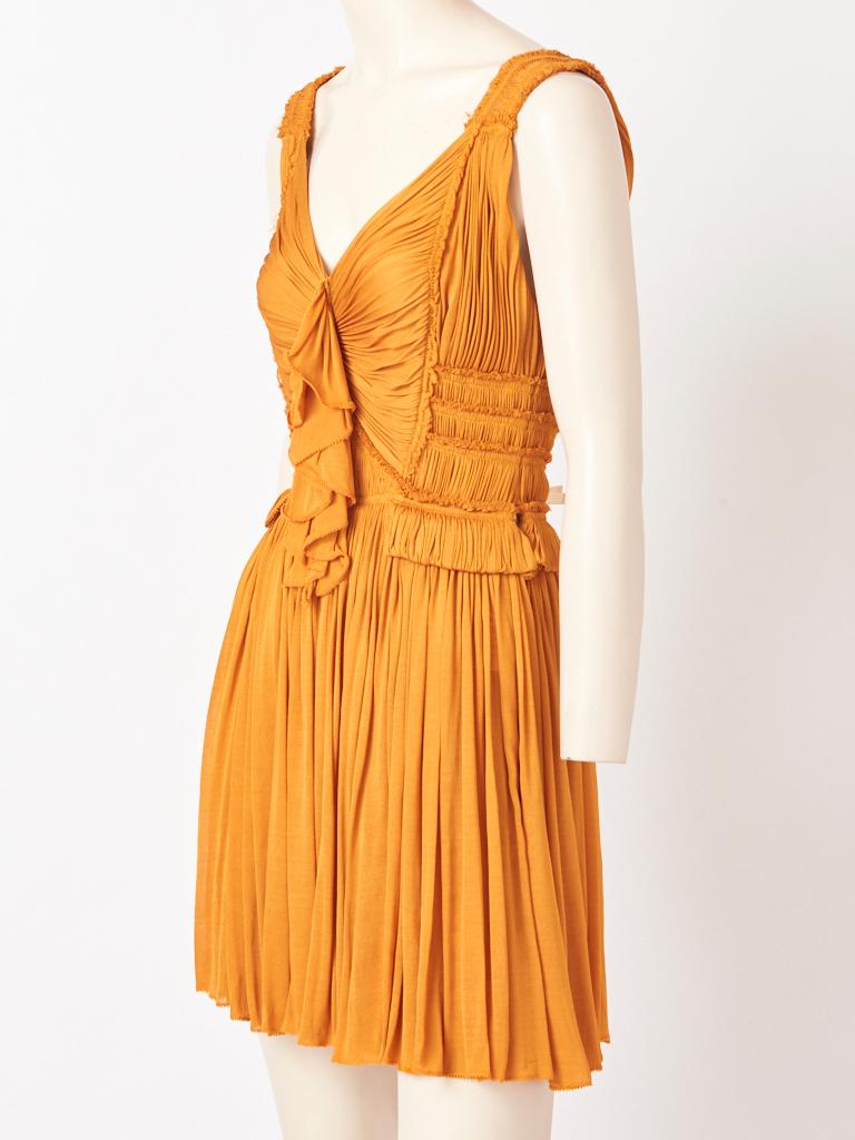 Isabel Toledo, marigold tone, silk jersey,  Madame Grès inspired sleeveless dress, having a v neckline, and pleating detail in horizontal and vertical directions at the bodice. Bodice has a middle vertical flounce. Skirt is gathered.
