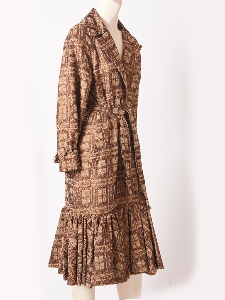 Isabel Toledo, patterned jacquard, in neutral tones of browns and beige with copper accents belted trench style coat.
Details include, a gathered flounce at knee extending to the hem, a deep inverted  center back pleat, and wide lapels. Coat is