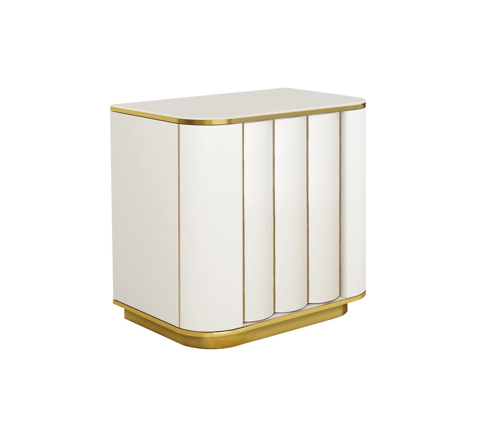 Designed by IC and beautifully crafted by Italian artisans, the Duilio nightstand features a ribbed door hiding one shelf.
The piece is elegantly enriched with brass, or powder-coated metal, details.
Finish: Ivory matte lacquered with polished