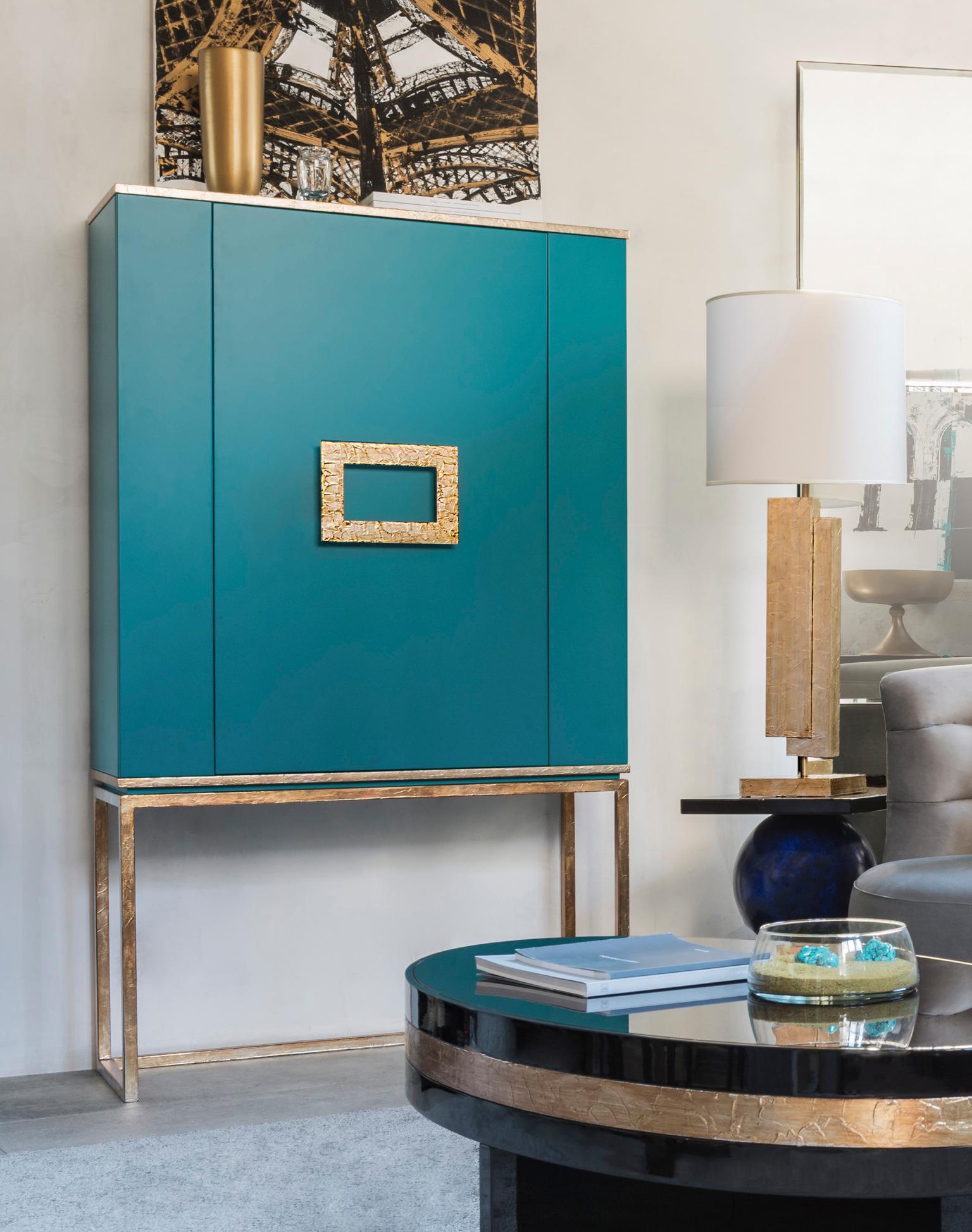 Designed by IC and crafted by expert Italian artisans, the Marion cabinet lays on a metal base and features geometrical details and a central handle in crinkled leaf. It’s perfect to store cocktail equipment and drink mats.
Finish: matte turquoise