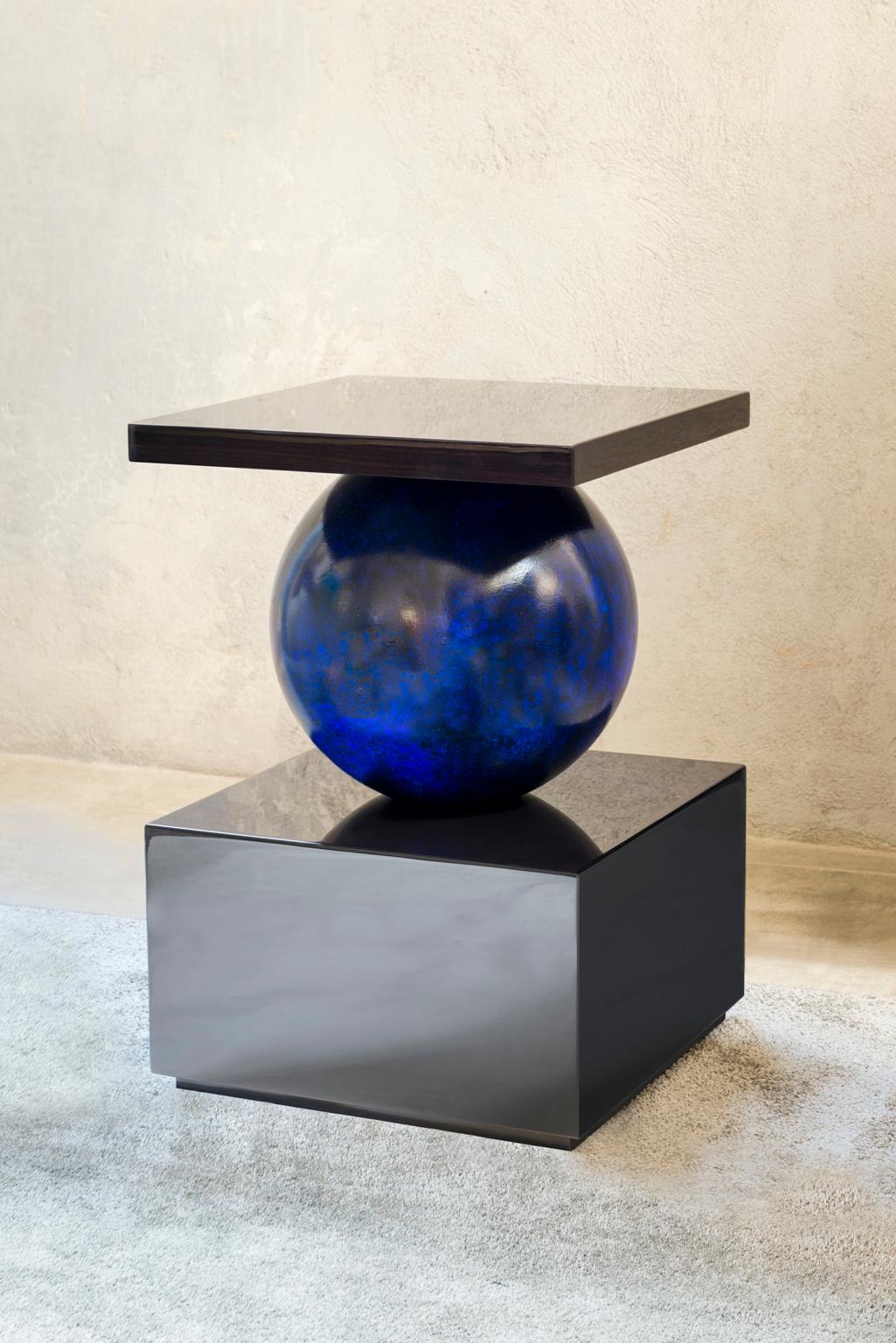 Designed by IC and impeccably realized by skilled Italian artisans, the Odilia side table features a geometrical top and bottom with central sphere. Its design is playful and elegant at the same time.
Finish: glossy dark oak and lapis