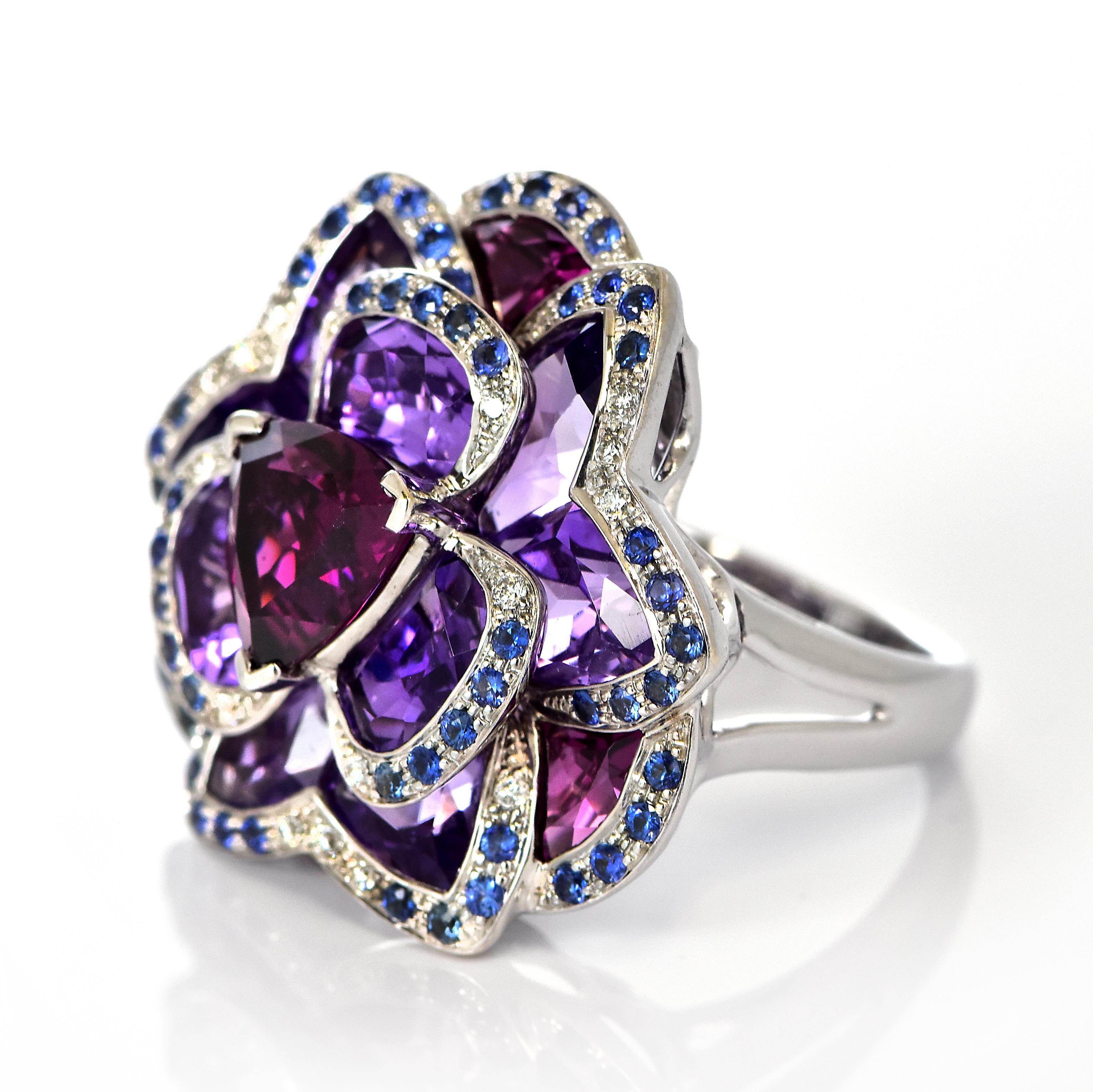 Une bague de cocktail absolument magnifique en or 18 carats composée de grenat rhodolite, d'améthyste, de saphirs et de diamants de la maison Isabelle Langlois Paris. Les grenats ont été ornés par les humains tout au long de l'histoire, de l'Égypte