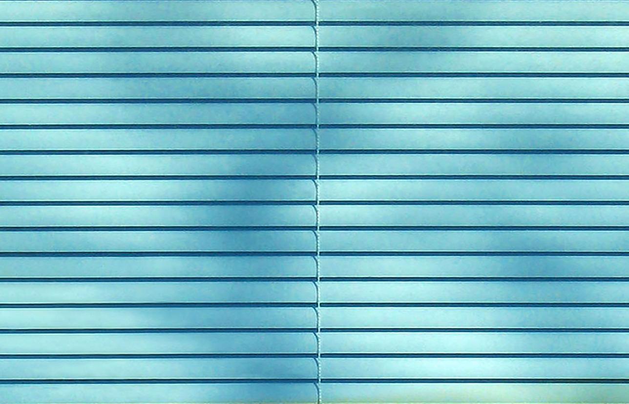 Y.A., 2025 von Isabelle Schneider ist ein zeitgenössisches fotografisches Mixed-Media-Werk. Das Foto zeigt Jalousien und hebt die Dichotomie zwischen grünem Fensterglas und den Himmelsreflexionen in der oberen Hälfte hervor, wodurch ein türkiser