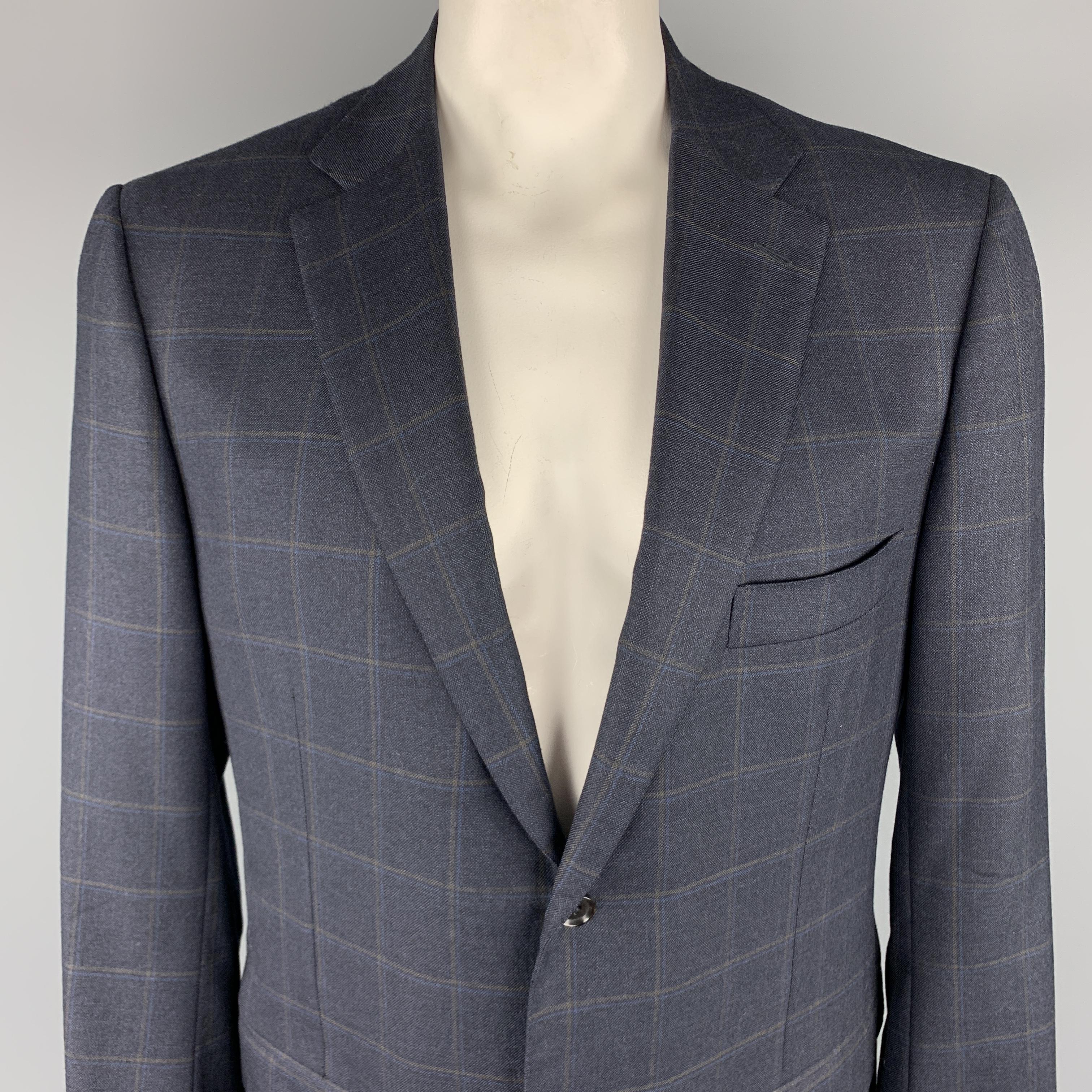 ISAIA Long Sport Coat comes in a navy tone in a window pane wool material, with a notch lapel, slit and flap pockets, two buttons at closure, single breasted, with functional buttons at cuffs, and double vent at back. Made in Italy.
 
Excellent