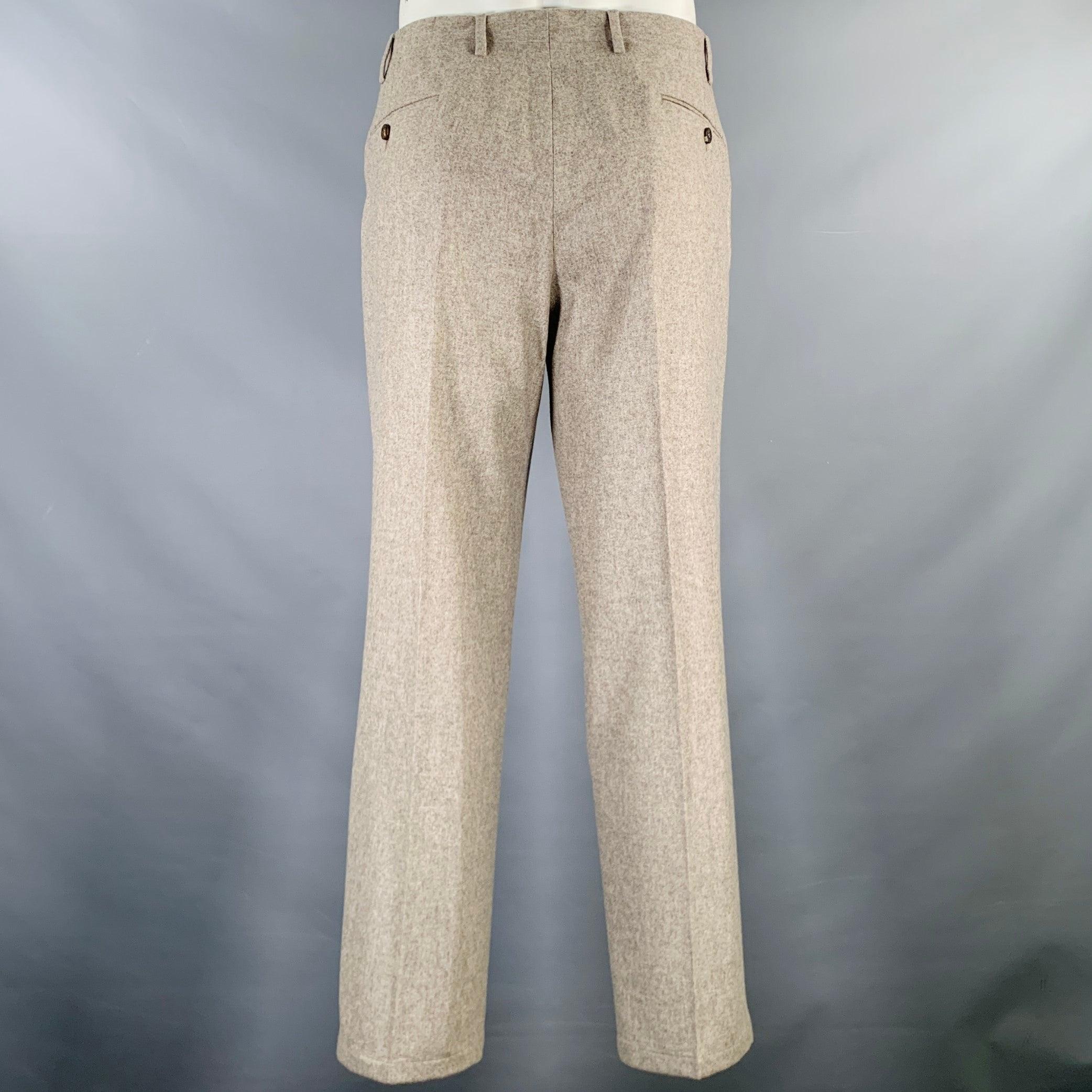 Pantalones de vestir ISAIA
en tejido de lana de color beige avena, con parte delantera plana y cierre con cremallera. Fabricado en Italia.Excelente estado de conservación. 

Marcado:   52R 

Medidas: 
  Cintura: 36 pulgadas Altura: 9 pulgadas