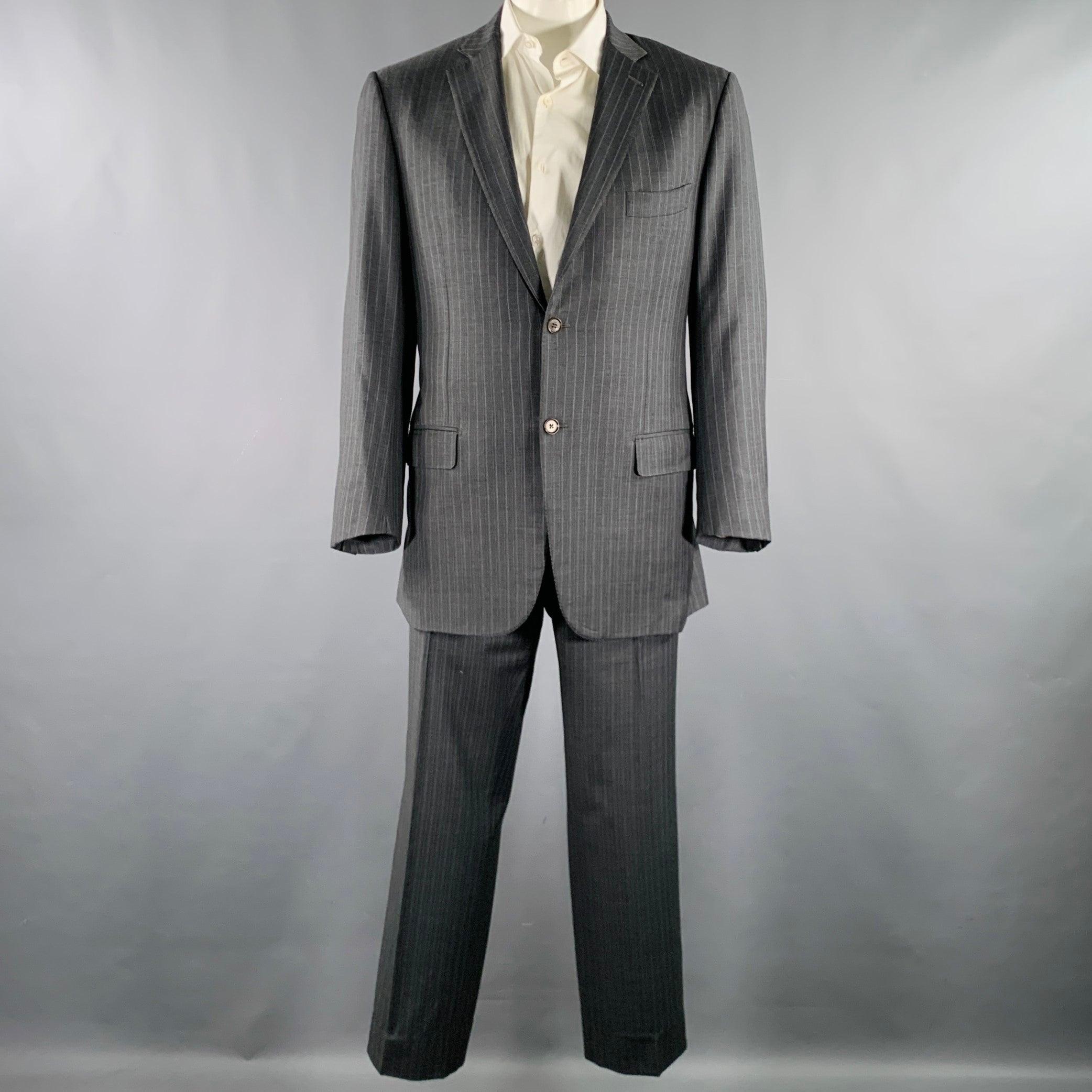 ISAIA suit
in a grey and light blue pinstripe wool with a full liner and includes a single breasted, double button sport coat with a notch lapel and matching flat front trousers. Made in Italy.Very Good Pre-Owned Condition. Moderate mark inside of