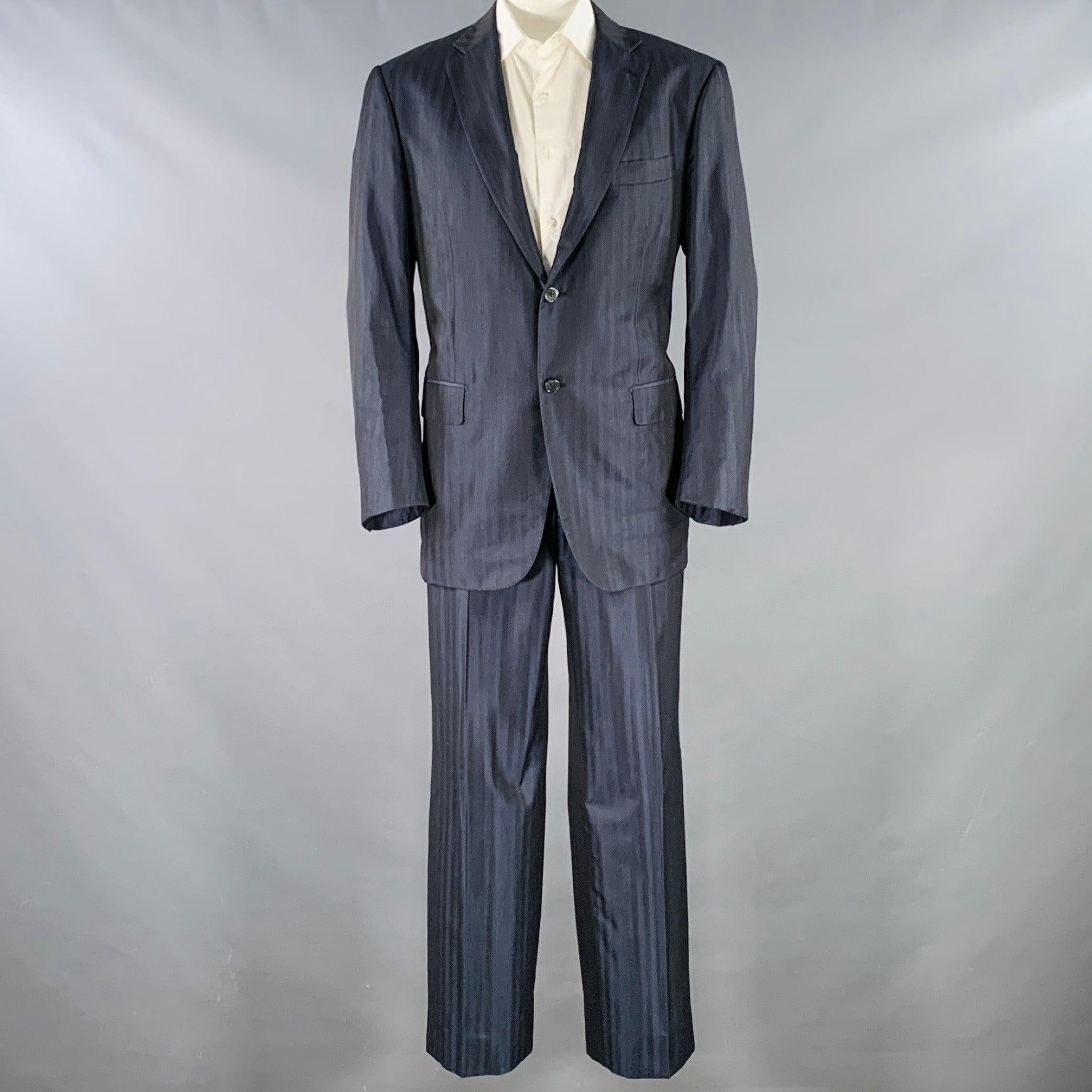 ISAIA Anzug
in einem marineblauen Woll-Seiden-Tonalstreifen-Stoff mit vollem Innenfutter und umfasst einen einreihigen Sportmantel mit Doppelknopfleiste und Kerbrevers sowie eine passende Hose mit flacher Vorderseite. Made in Italy. sehr guter