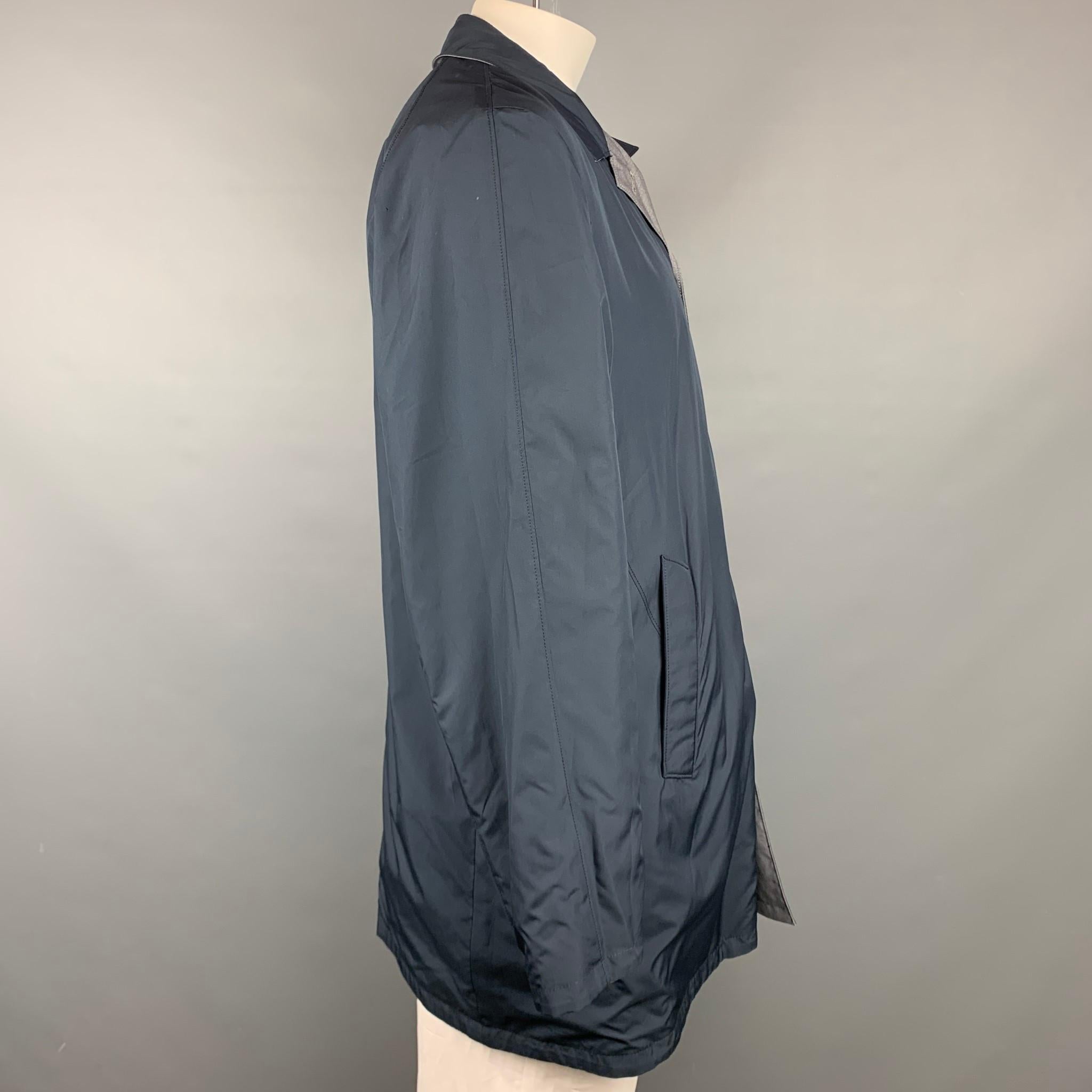 ISAIA coat comes in a navy & grey two toned wool / polyester featuring a reversible style, slit pockets, spread collar, and a buttoned closure. Made in Italy.

Very Good Pre-Owned Condition.
Marked: IT 56

Measurements:

Shoulder: 17.5 in.
Chest: 46