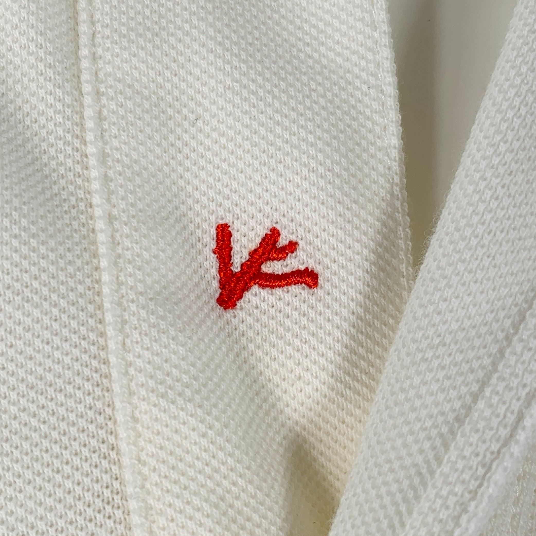 Polo ISAIA de piqué de algodón blanco roto, con cuello abierto, mangas cortas y media tapeta abotonada. Made in Italy. Muy buen estado de conservación. Pequeñas marcas y signos de desgaste. 

Marcado:   M 

Medidas: 
 
Hombro 17,5 pulgadas Pecho: 41