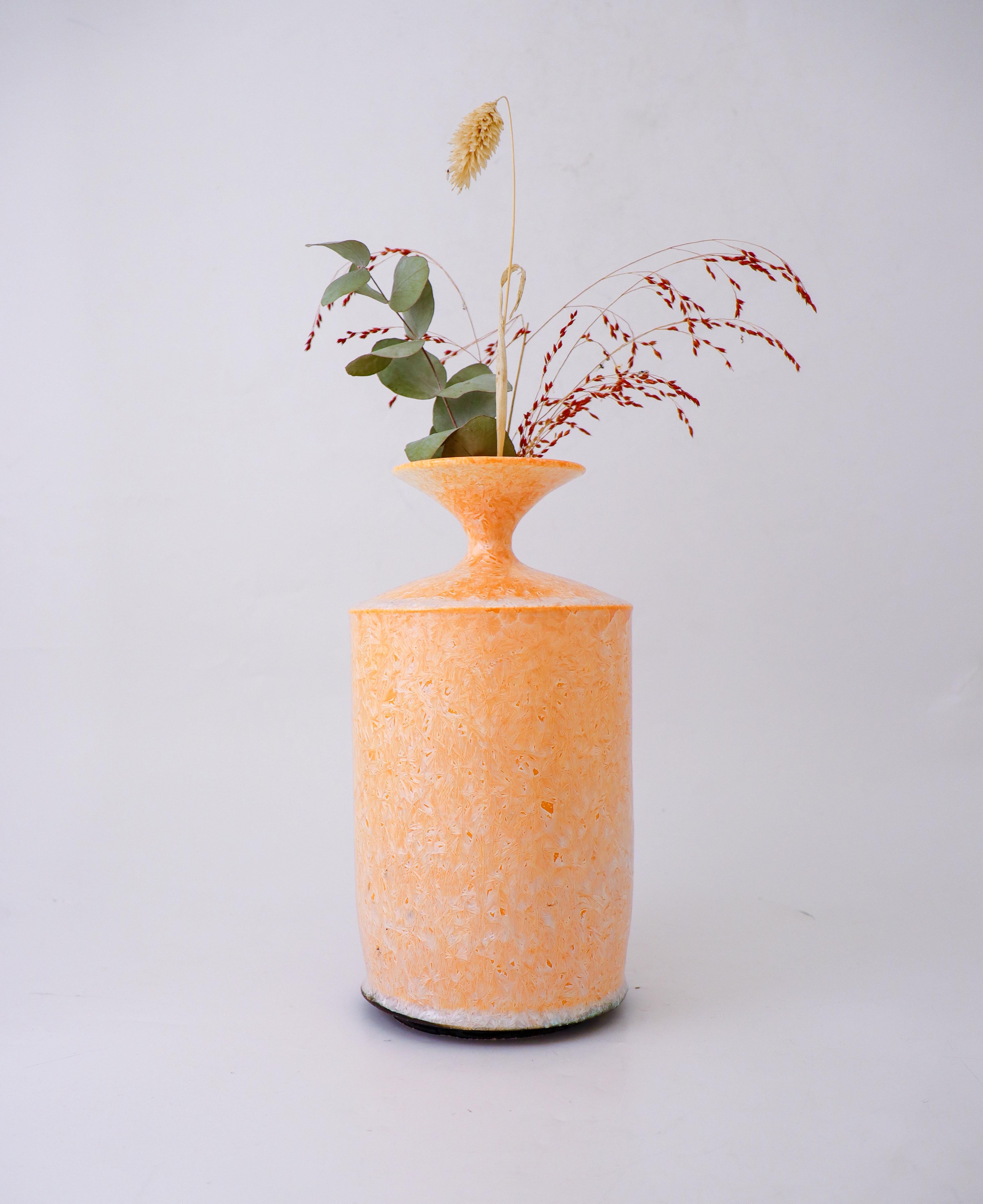 Ce magnifique vase contemporain en céramique d'Isak Isak/One présente un étonnant motif abstrait dans des tons abricot. Le vase mesure 25 cm de haut et est fabriqué à la main avec une finition brillante. La signature de l'artiste est incisée sur le