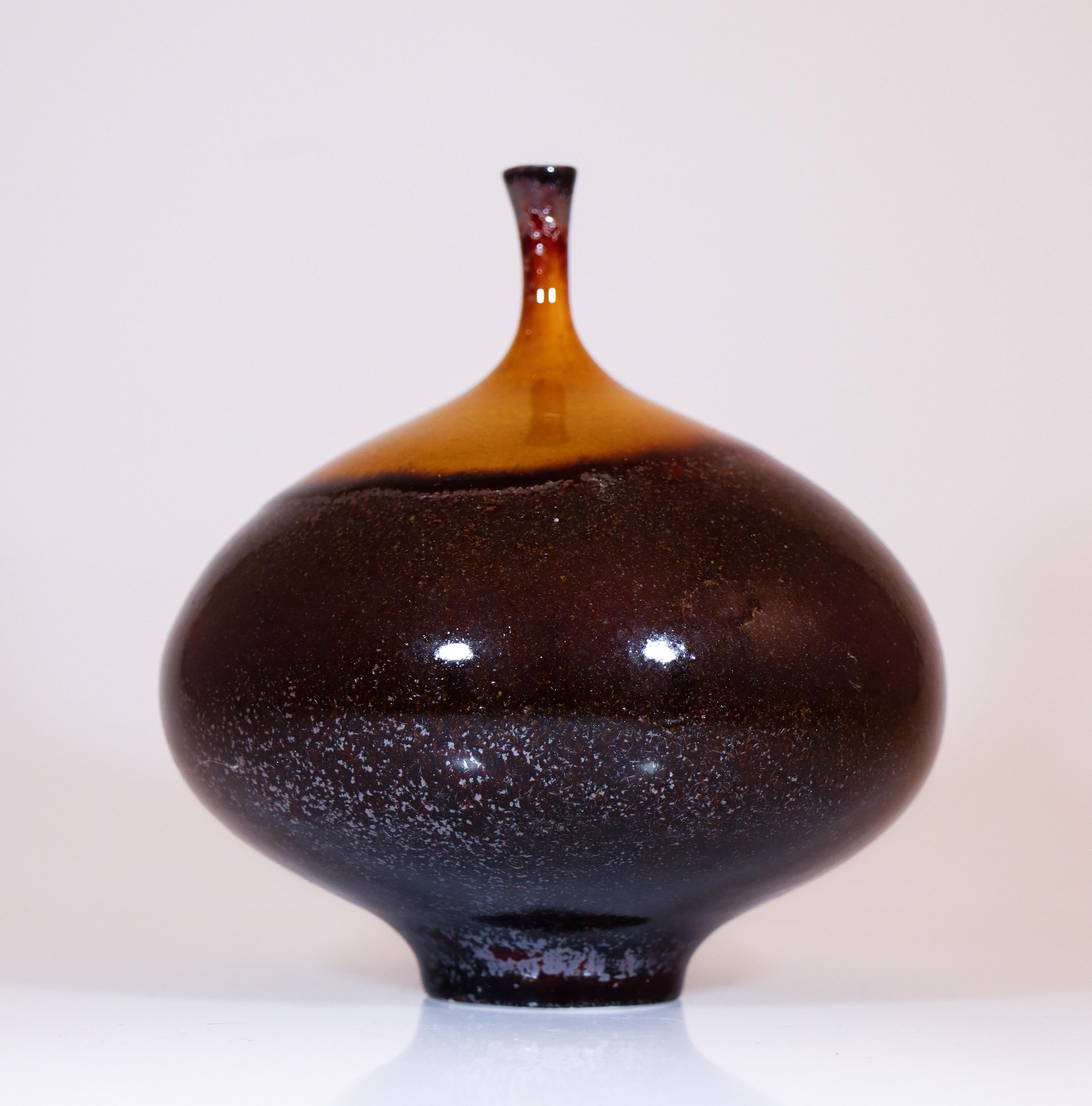 A black and brown vase with a crystalline glaze designed by Isak Isaksson in Sweden. The vase is 14 cm (5.6