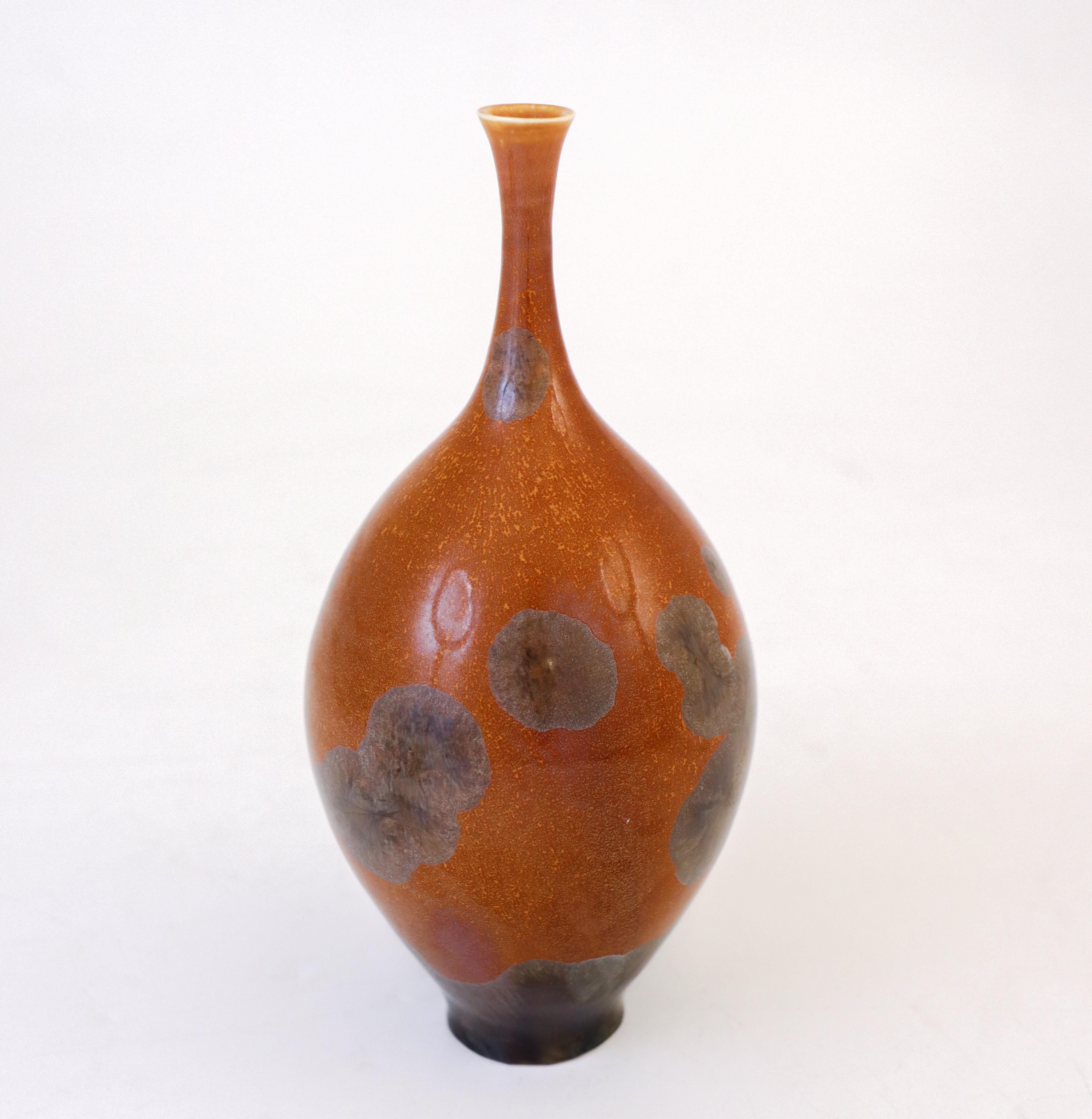 A brown vase with a lovely crystalline glaze in silver designed by Isak Isaksson in Sweden. The vase is 17.5 cm (7