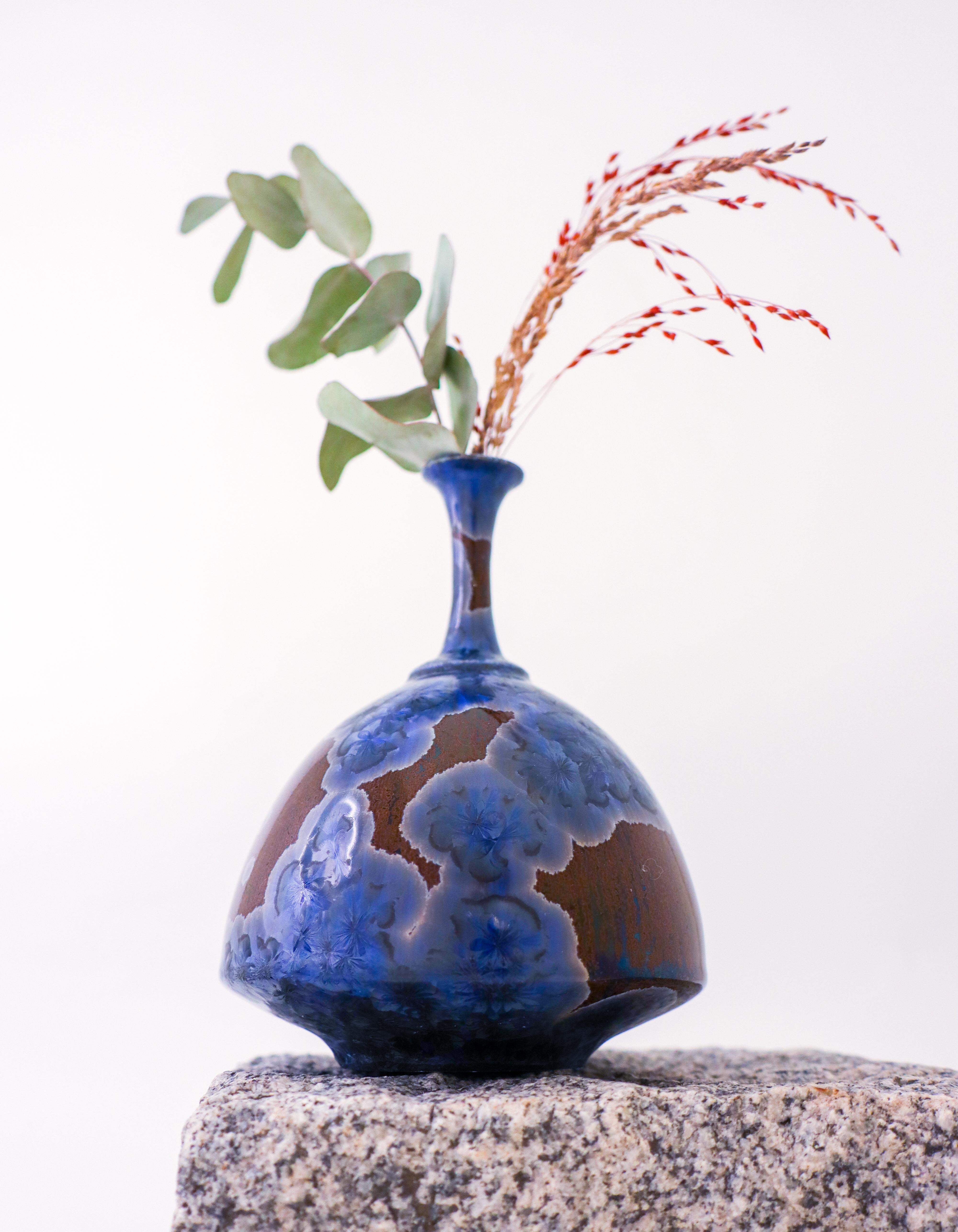 A brown vase with a blue crystalline glaze designed by Isak Isaksson in Sweden. The vase is 15.5 cm (6.2