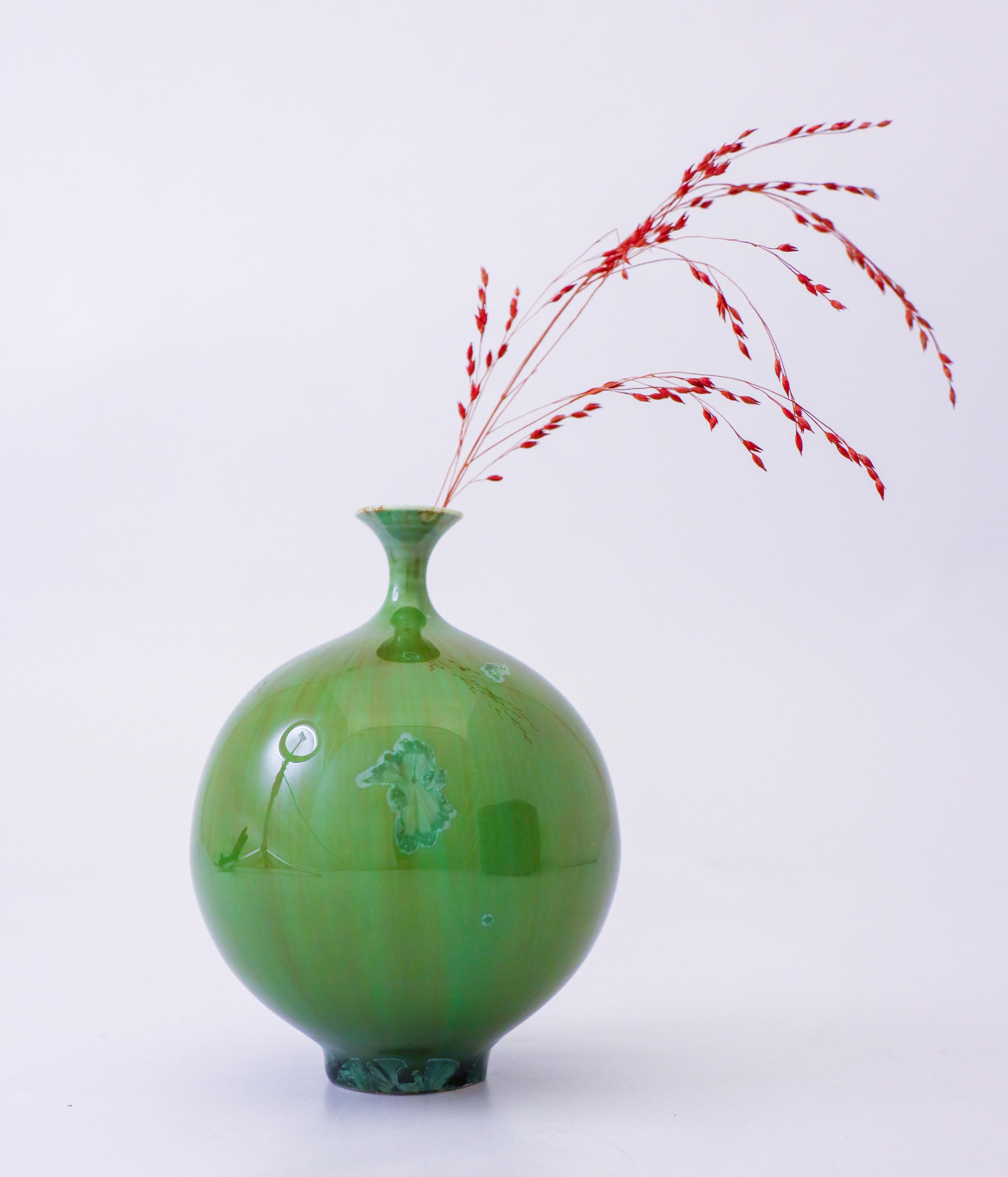 A beautiful green vase with a green crystalline glaze designed by Isak Isaksson in Sweden. The vase is 12.5 cm (5