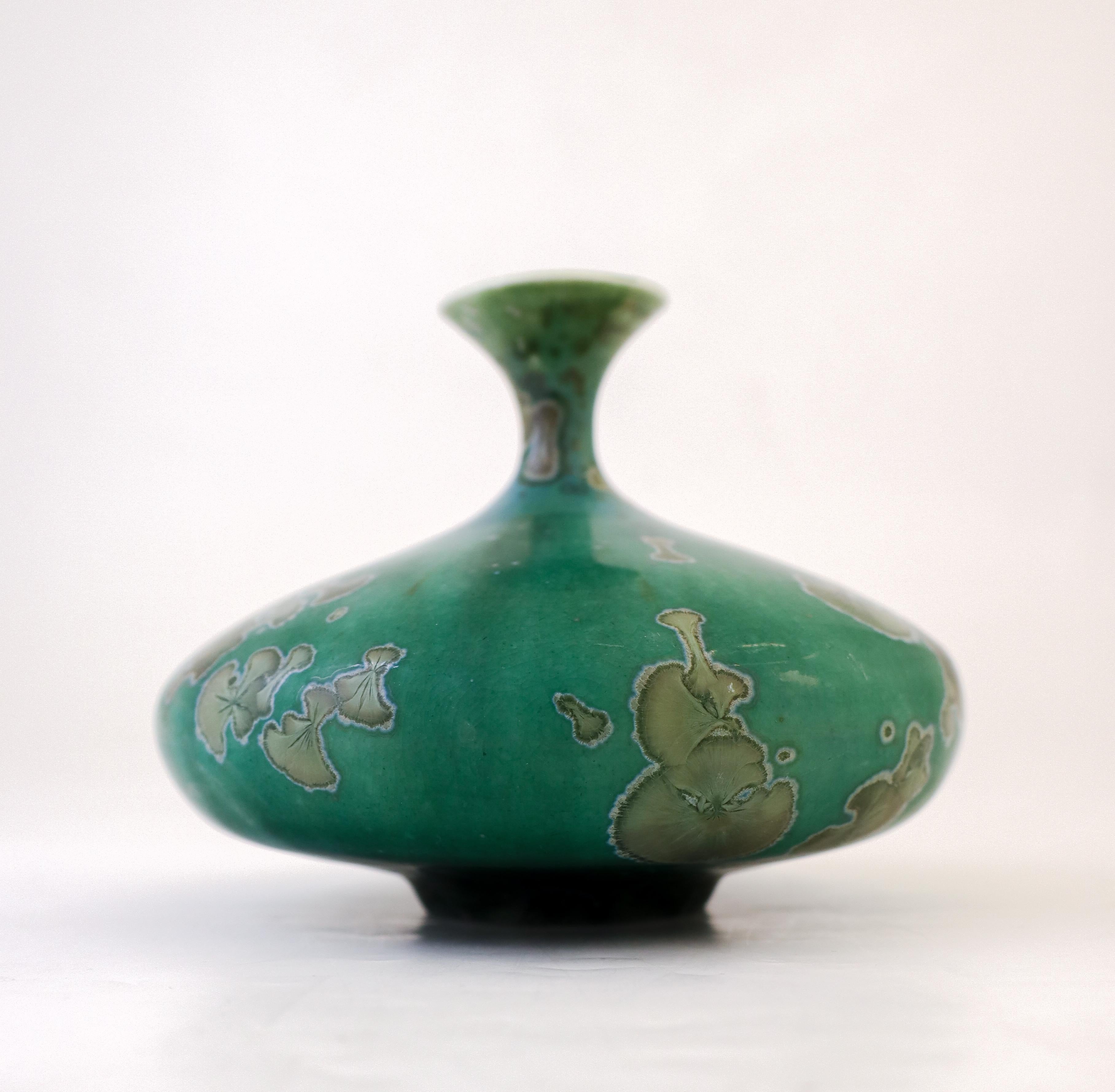 A green vase with a stunning crystalline glaze designed by Isak Isaksson in Sweden. The vase is 10 cm (4