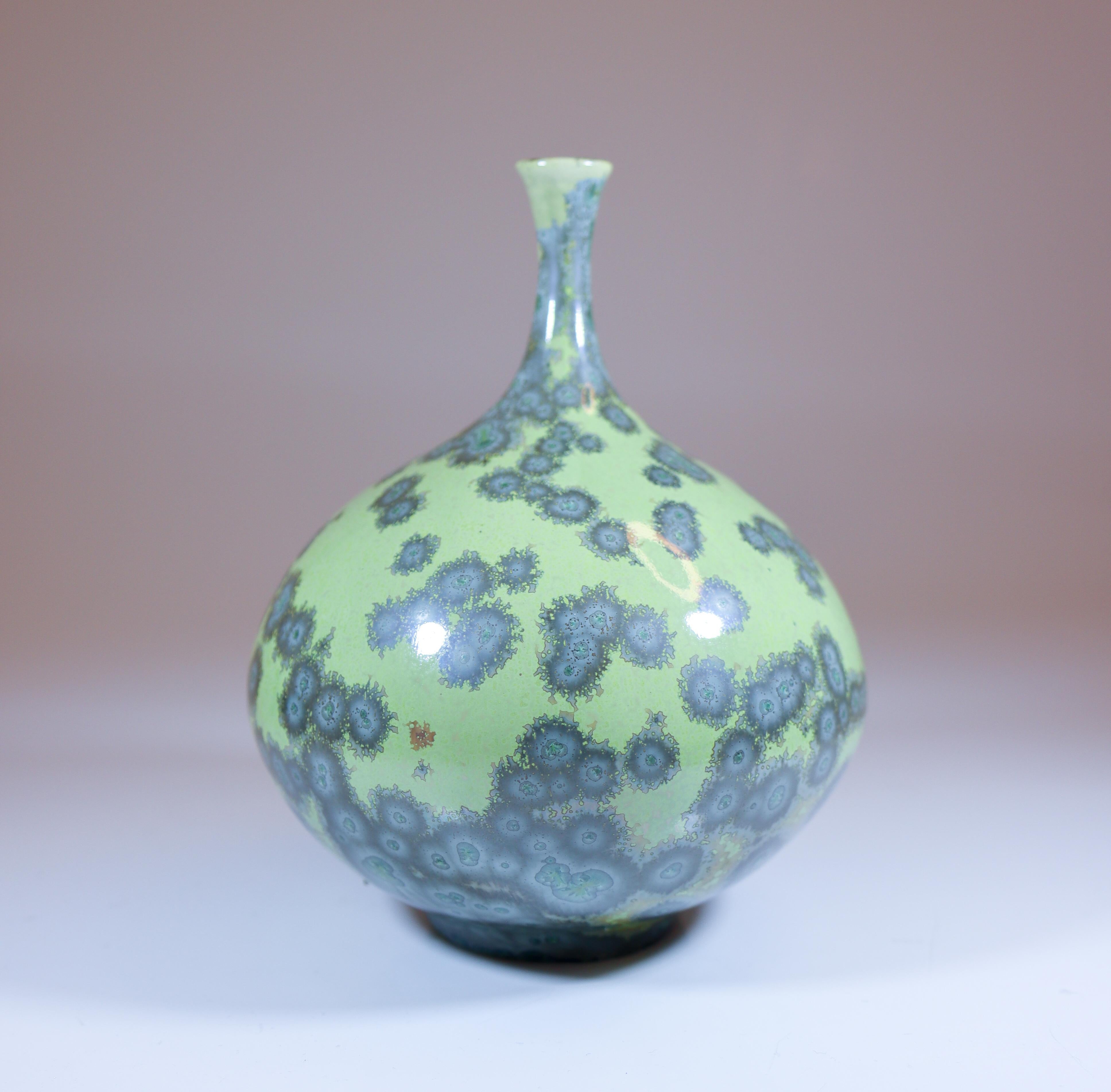 Un vase vert avec une belle glaçure cristalline conçu par Isak Isaksson en Suède. Le vase mesure 13 cm de haut et environ 9 cm de large. Il est en excellent état. Il s'agit d'un vase unique, tourné à la main par Isak Isaksson. Il est signé comme sur