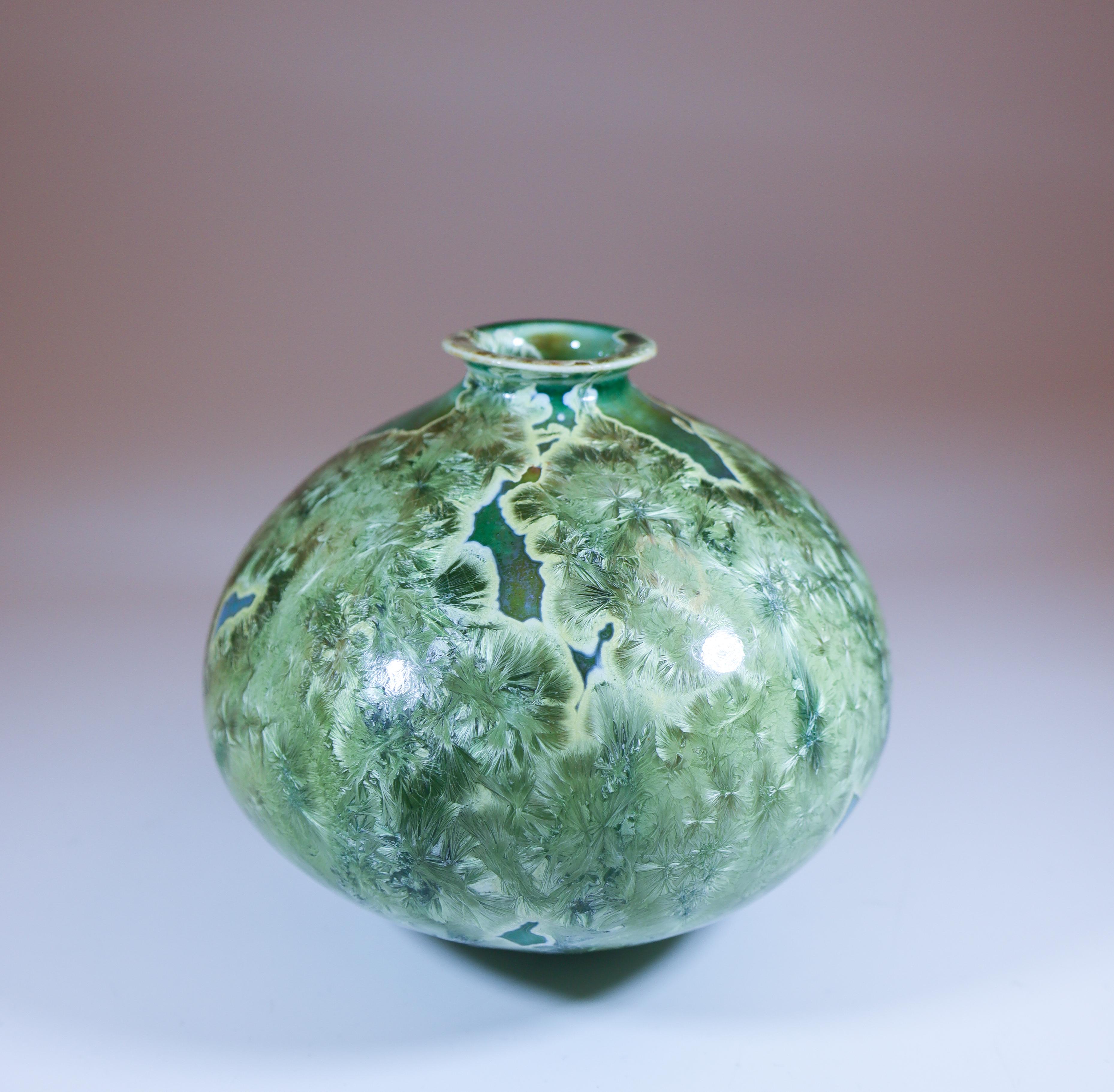 Un vase vert avec une belle glaçure cristalline conçu par Isak Isaksson en Suède. Le vase mesure 10 cm de haut et environ 12,5 cm de large. Il est en excellent état. Il s'agit d'un vase unique, tourné à la main par Isak Isaksson. Il est signé comme
