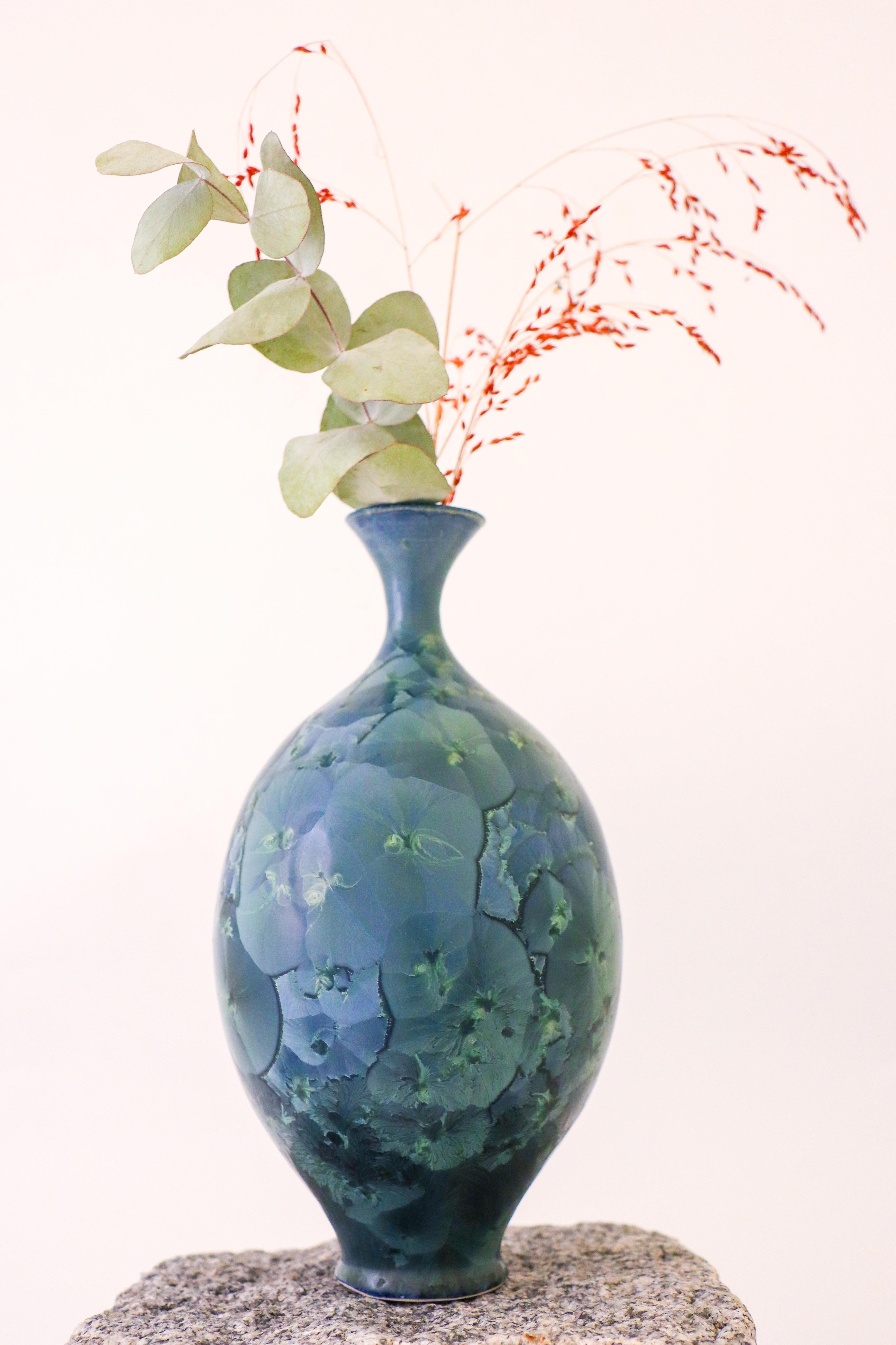 A beautiful green / blue-toned vase with a stunning crystalline glaze designed by Isak Isaksson in Sweden. The vase is 22.5 cm (9