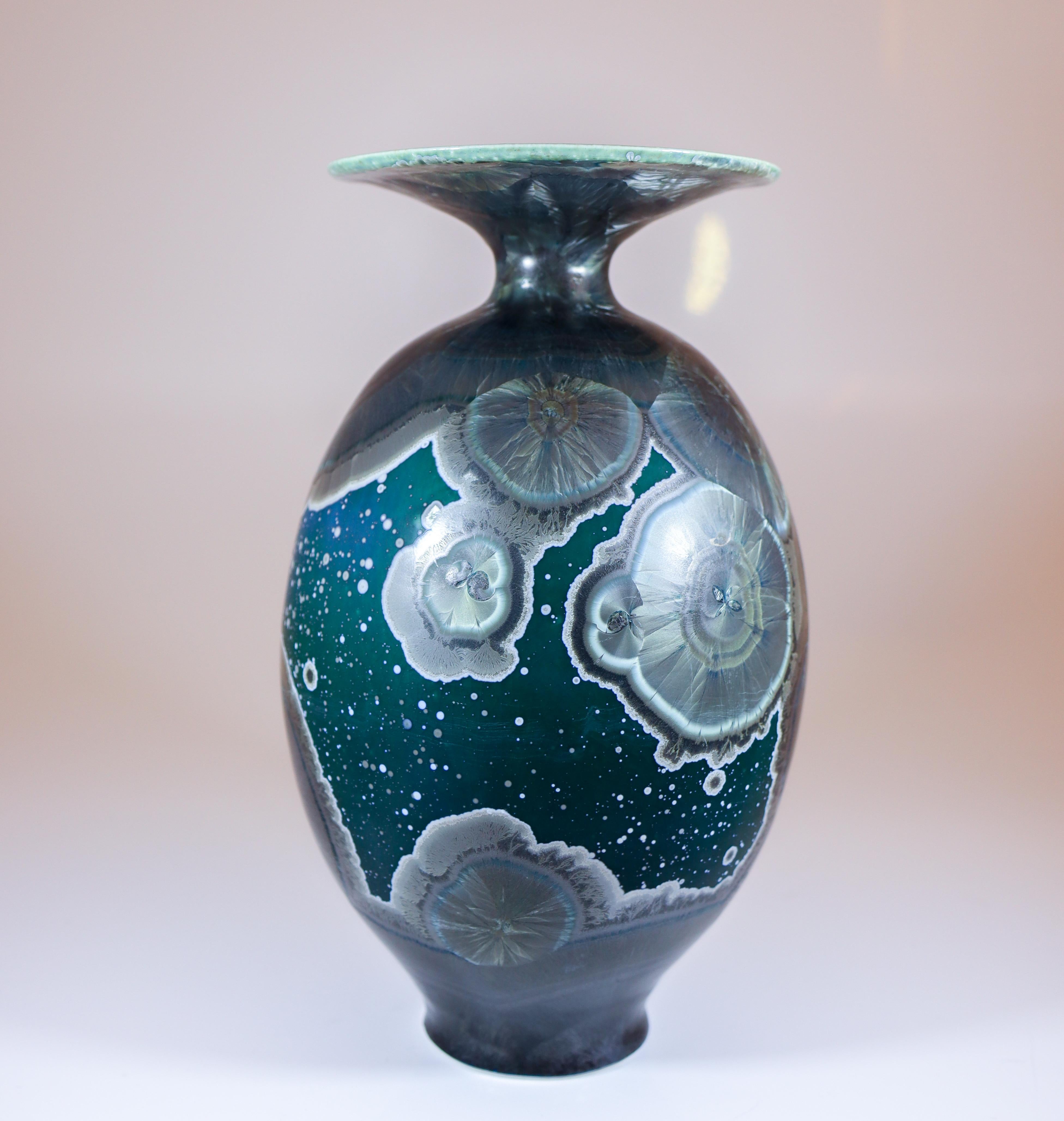 A stunning green vase with amazing crystalline glaze in silver designed by Isak Isaksson in Sweden. The vase is 19.5 cm (7.8