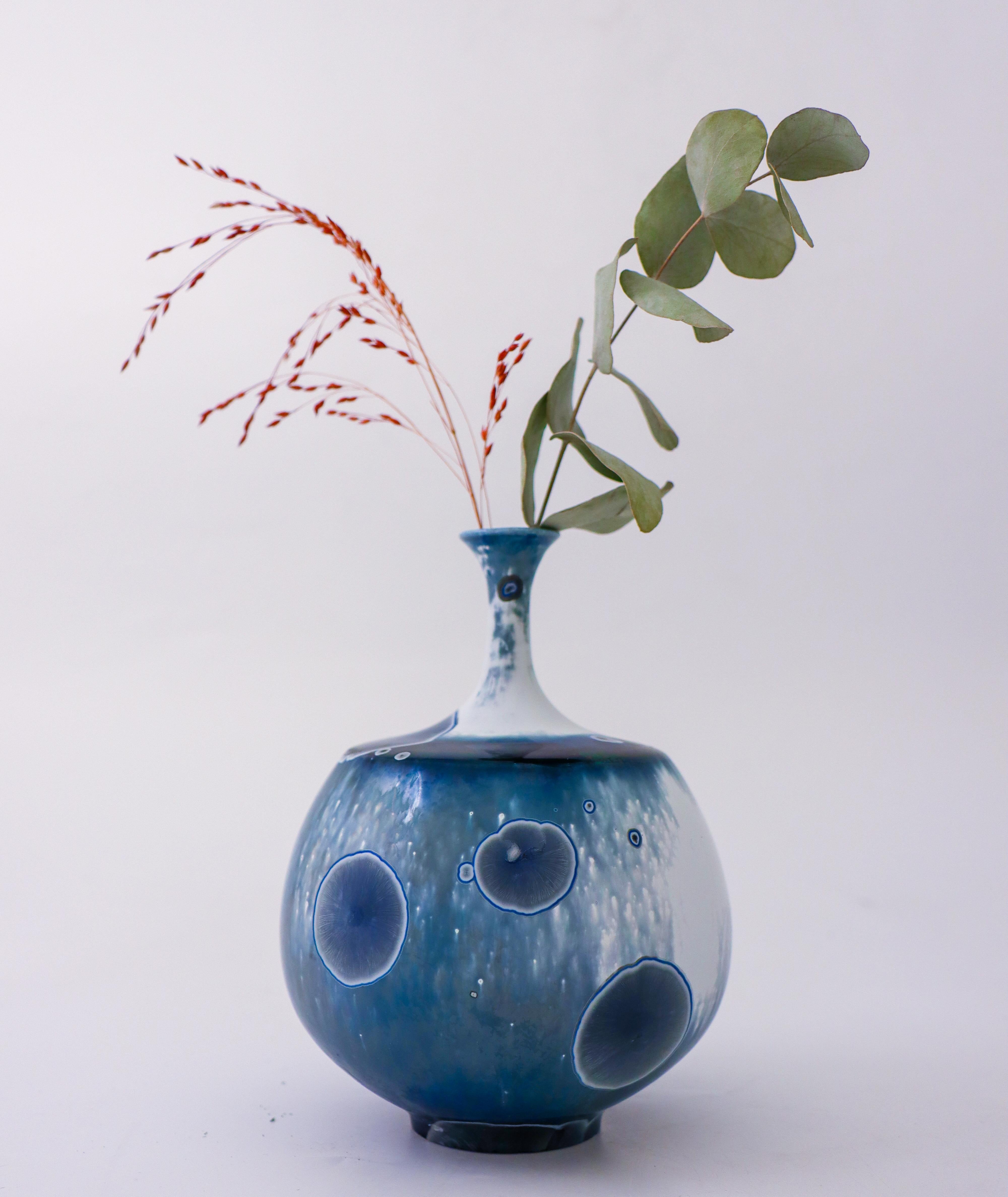 A white & blue vase with a lovely crystalline glaze designed by Isak Isaksson in Sweden. The vase is 16 cm (6.4