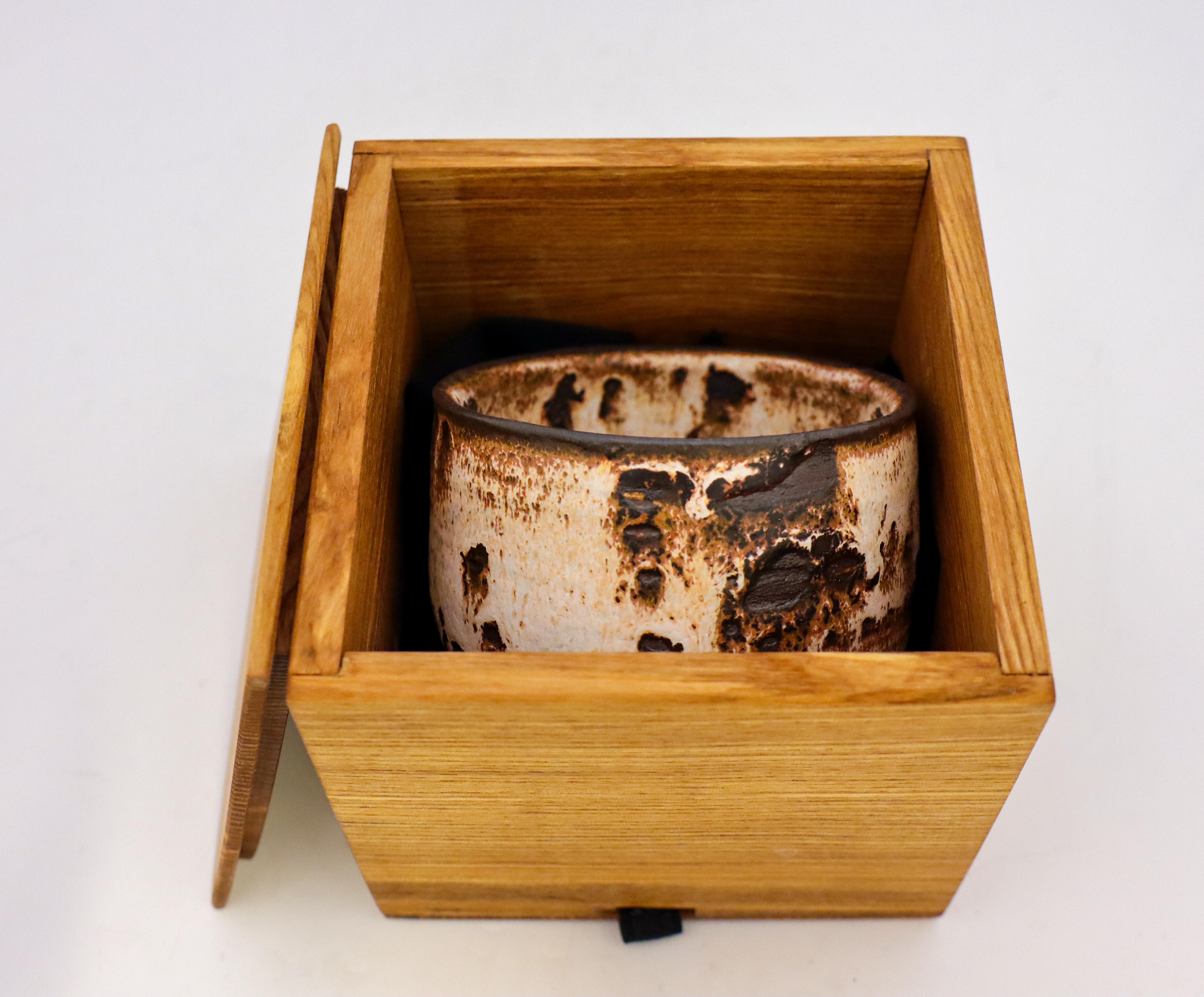 Eine schöne braun-weiße Chawan-Schale oder Teeschale mit einer Shino-Glasur, die der zeitgenössische schwedische Künstler Isak Isaksson in seinem eigenen Atelier entworfen hat. Die Schale hat einen Durchmesser von 11 cm und eine Höhe von 7 cm und