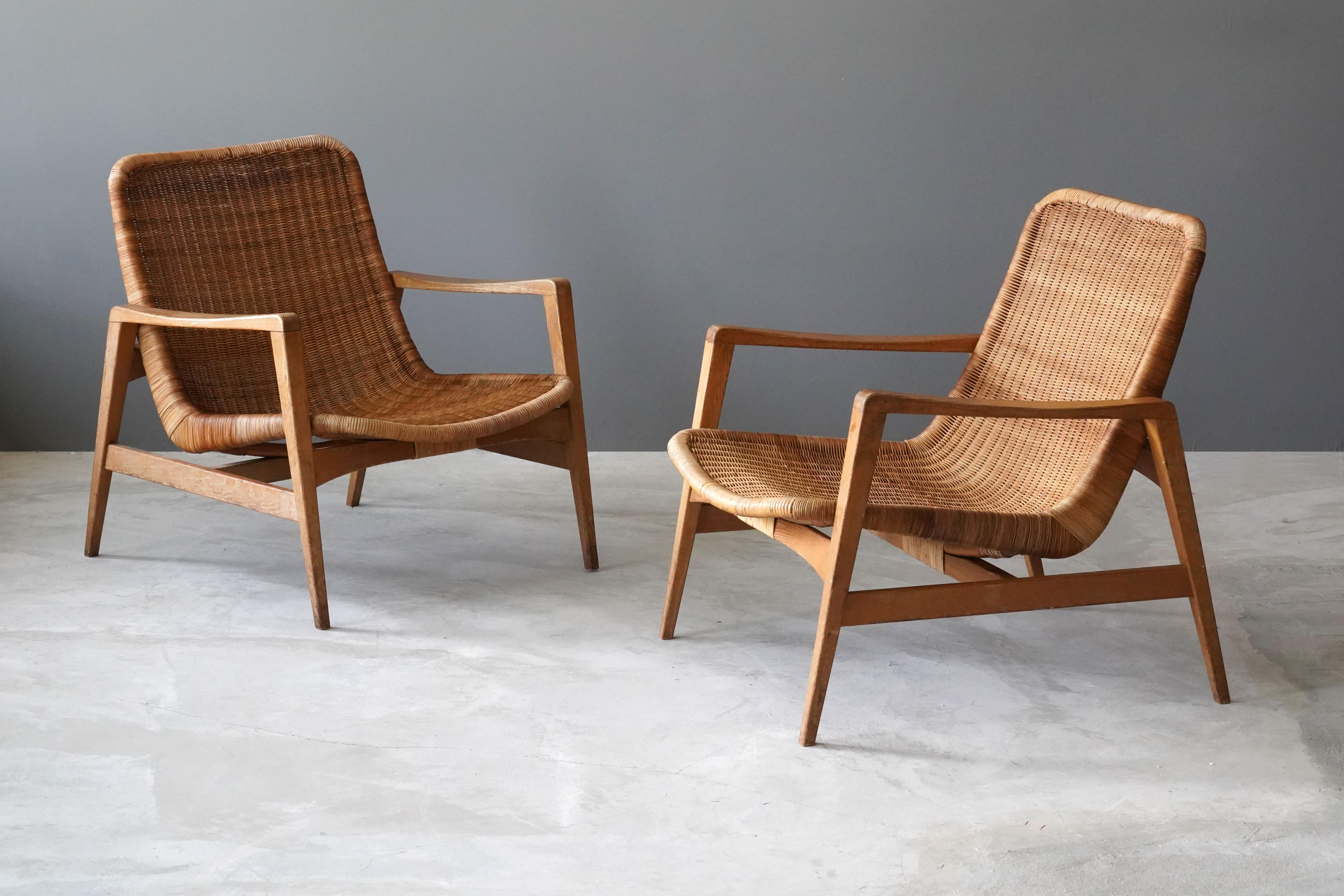 A pair of unusual lounge chairs, production attributed to Yamakawa Rattan, Tokyo, Japan, 1960s. Design attributed to Isamu Kenmochi who designed for the firm. In finely sculpted wood and rattan. 

Other designers of the period include Isamu