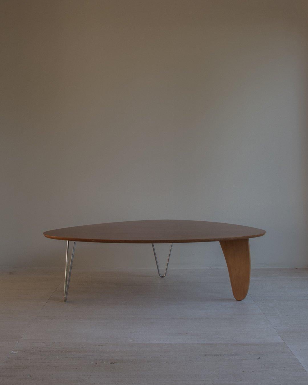 Table basse Rudder, modèle IN-52, conçue en 1944 par Isamu Noguchi - produite vers les années 1970. Table en bois de bouleau et placage de bois, avec un plateau amorphe reposant sur deux pieds en épingle à cheveux chromés et un support en forme de