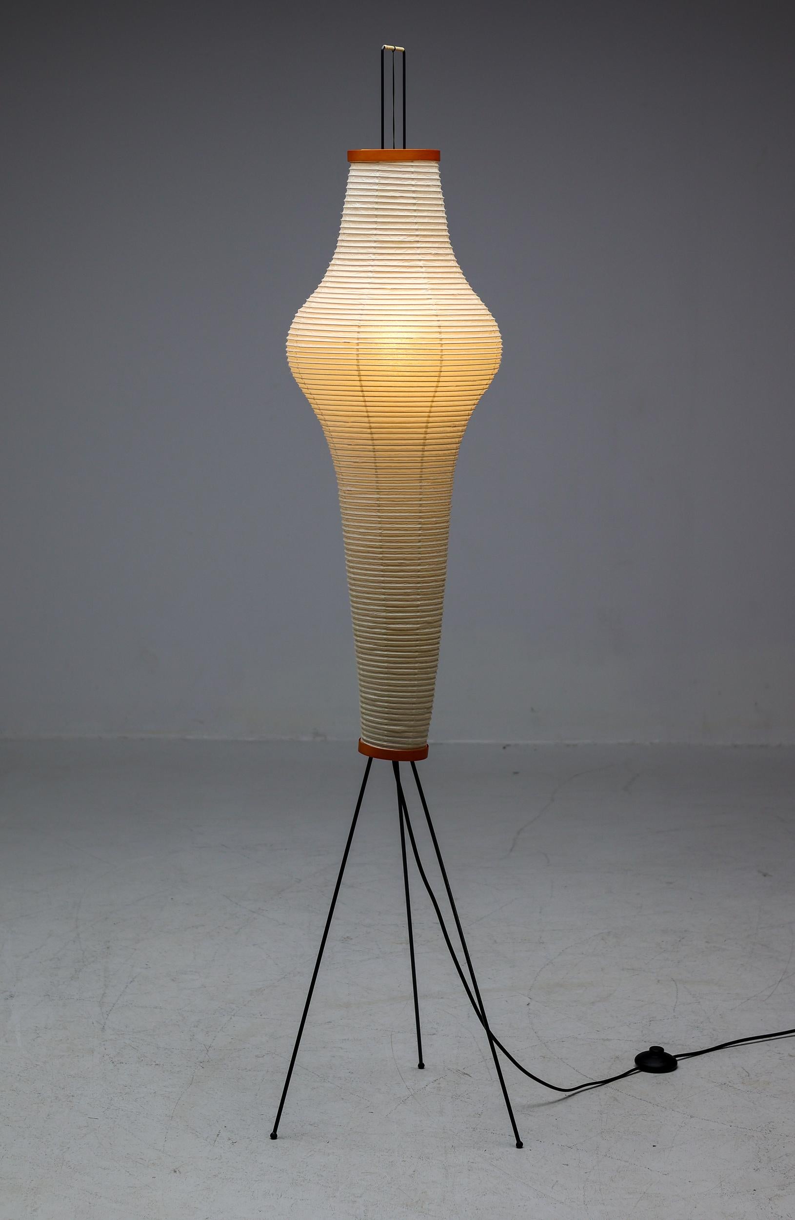 Akari 14A floor lamp designed by Isamu Noguchi, 1951. Manufactured by Ozeki & Co. in Japan. 
Bambu structure covered by washi paper supported by a coated metal base. Wired for U.S. standards. 
This fixture has one socket. We recommend one E27 25-75