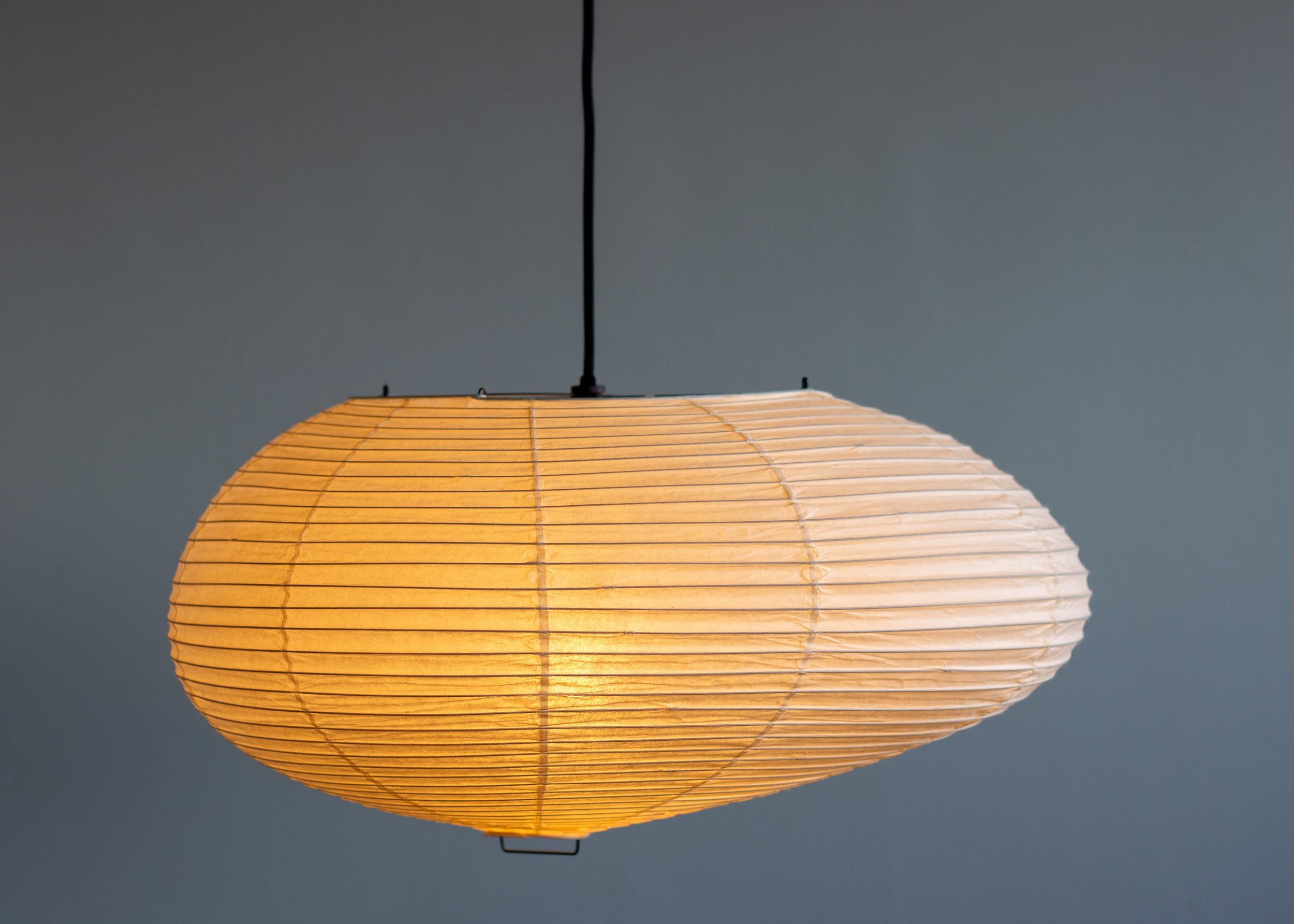 Akari 16A pendant designed by Isamu Noguchi, 1951. Manufactured by Ozeki & Co. in Japan. 
Bambu structure covered by washi paper. Wired for U.S. standards. 
Recent version, new cord and canopy from Noguchi Museum. 
This fixture has one socket. We