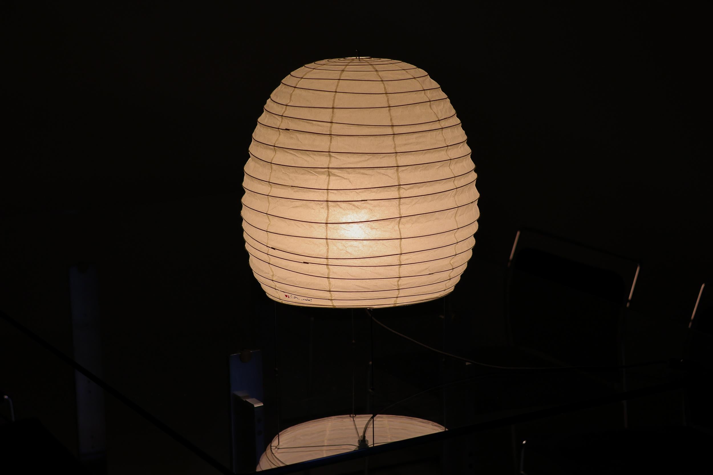 Numéro de modèle 20N lampe de table ou lampadaire par Isamu Noguchi pour Akari. 
Version originale fabriquée par Ozeki & co au Japon. 
Papier de riz, métal émaillé. Le fabricant a conservé le cachet d'origine, la boîte d'origine est