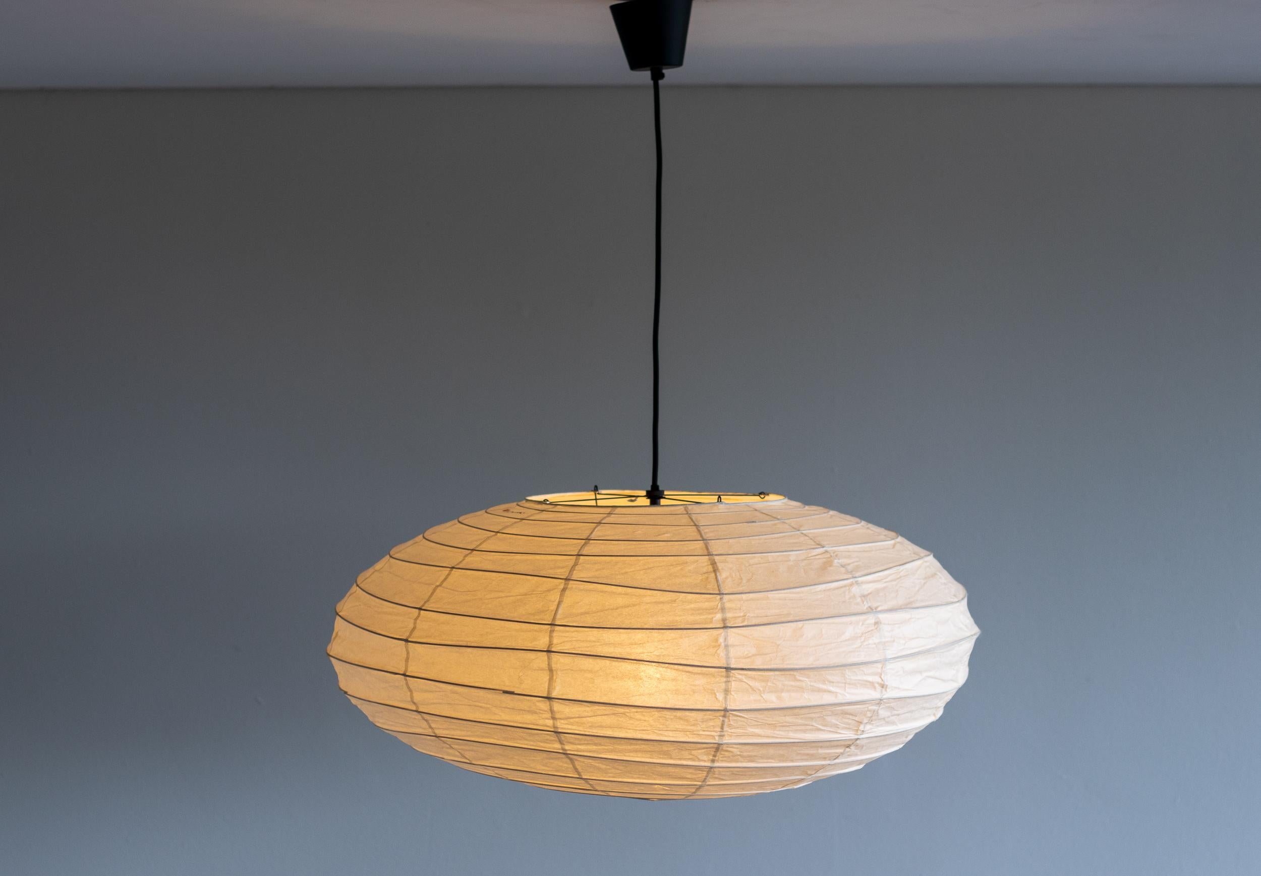 Akari 70EN lamp designed by Isamu Noguchi, 1951. Manufactured by Ozeki & Co. in Japan. 
Bambu structure covered by washi paper. Rewired for U.S. standards. 
New cord and canopy from Noguchi Museum. 
This fixture has one socket. We recommend one