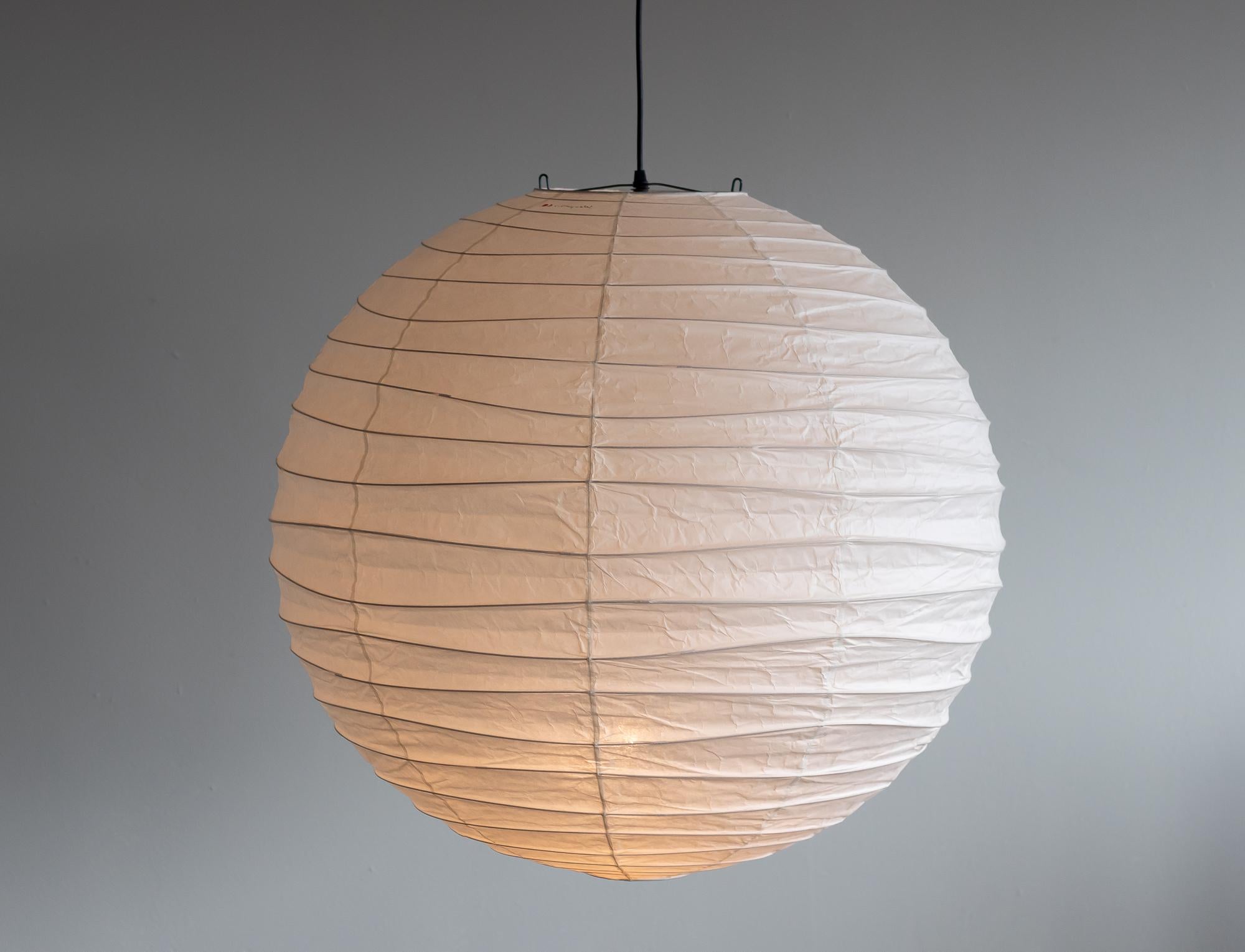 Akari 75D lamp designed by Isamu Noguchi, 1951. Manufactured by Ozeki & Co. in Japan. 
Bambu structure covered by washi paper. Rewired for U.S. standards. New cord and canopy from Noguchi Museum. 
This fixture has one socket. We recommend one E27