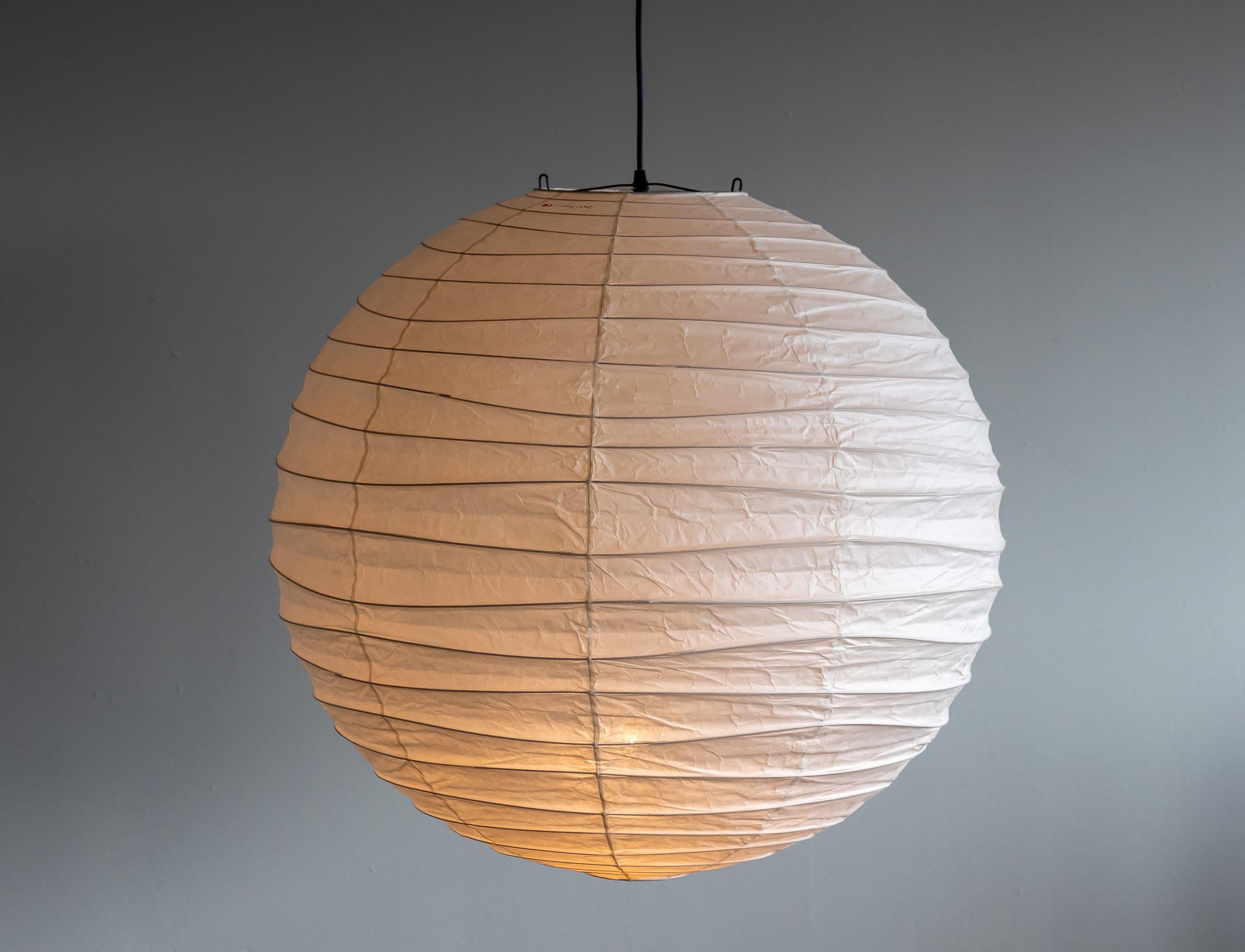 Akari 75D lamp designed by Isamu Noguchi, 1951. Manufactured by Ozeki & Co. in Japan. 
Bambu structure covered by washi paper. Rewired for U.S. standards. 
New cord and canopy from Noguchi Museum. 
This fixture has one socket. We recommend one