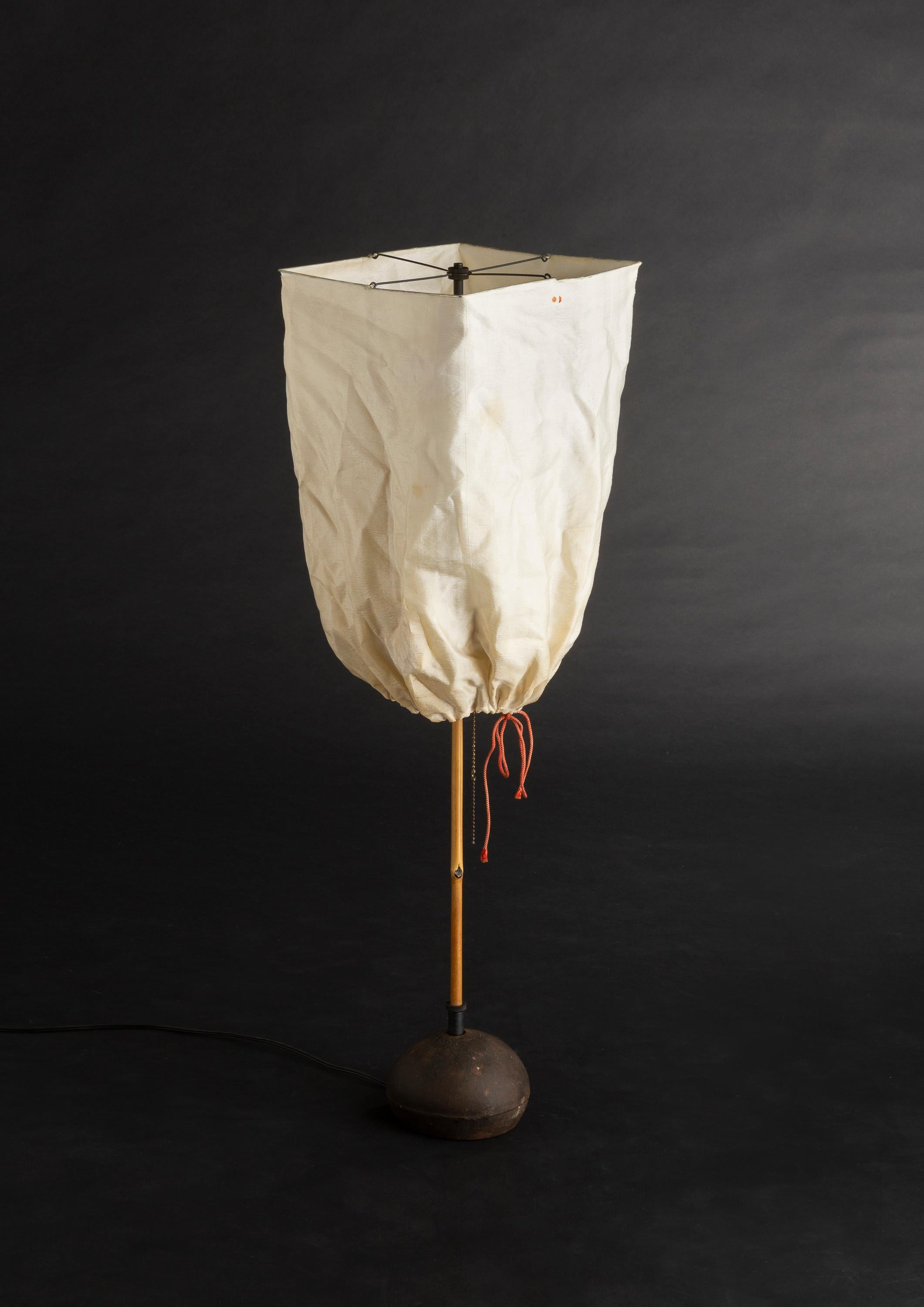 ISAMU NOGUCHI
Akari model “BB2-K1”
Original shade in silk & red string
Structure in black lacquered metal & pebble base in cast iron and bamboo stem
Hand-made form realized by Ozeki Company, Gifu, Japan
Series started in 1951
Height: 27 in. /