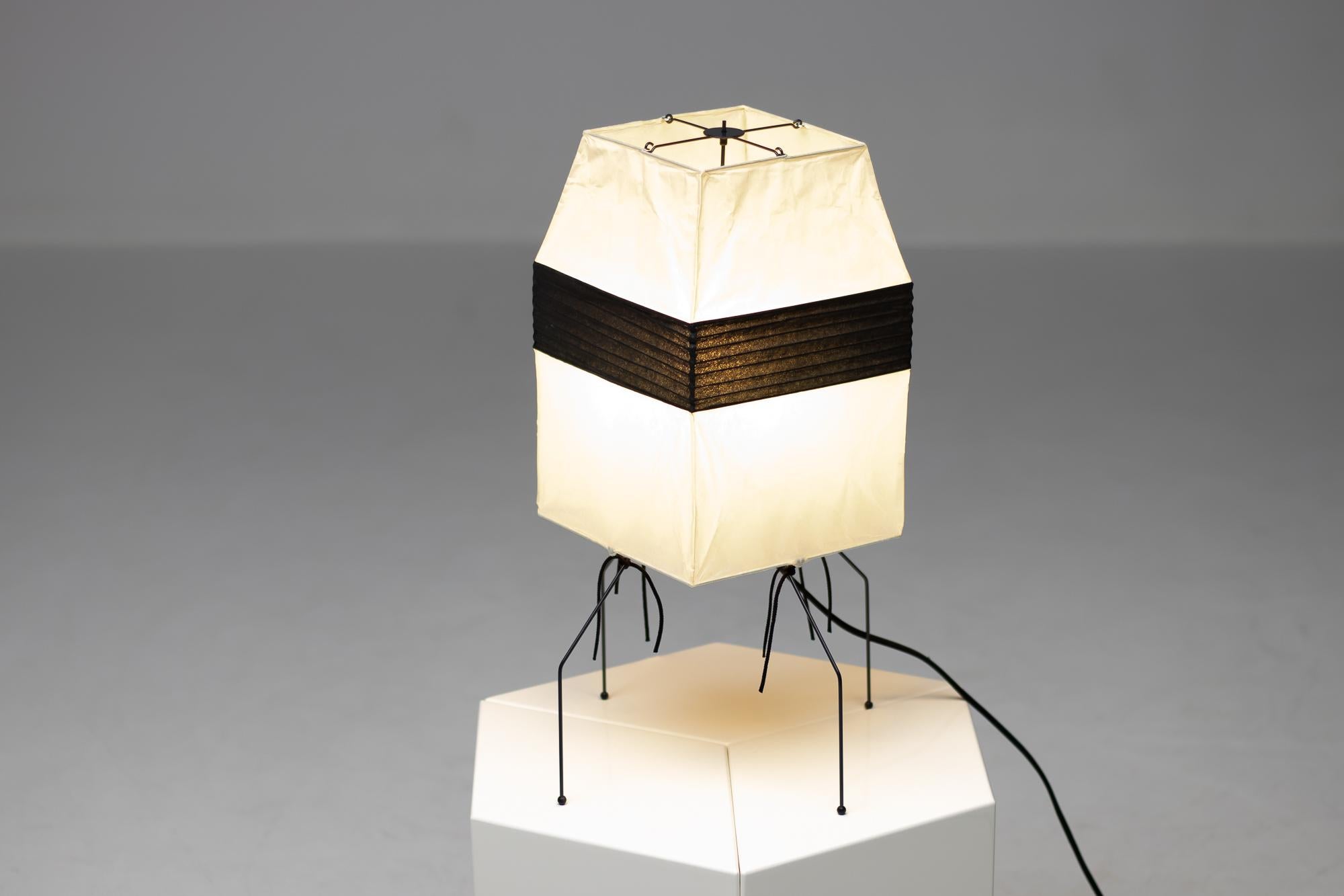 Model number UF 1-H table lamp in black and white by Isamu Noguchi for Akari. Designed and manufactured in Japan. 
Rice paper, enameled metal. All original excellent condition. Retains manufacturer's original stamp. 
With the original box.
Takes