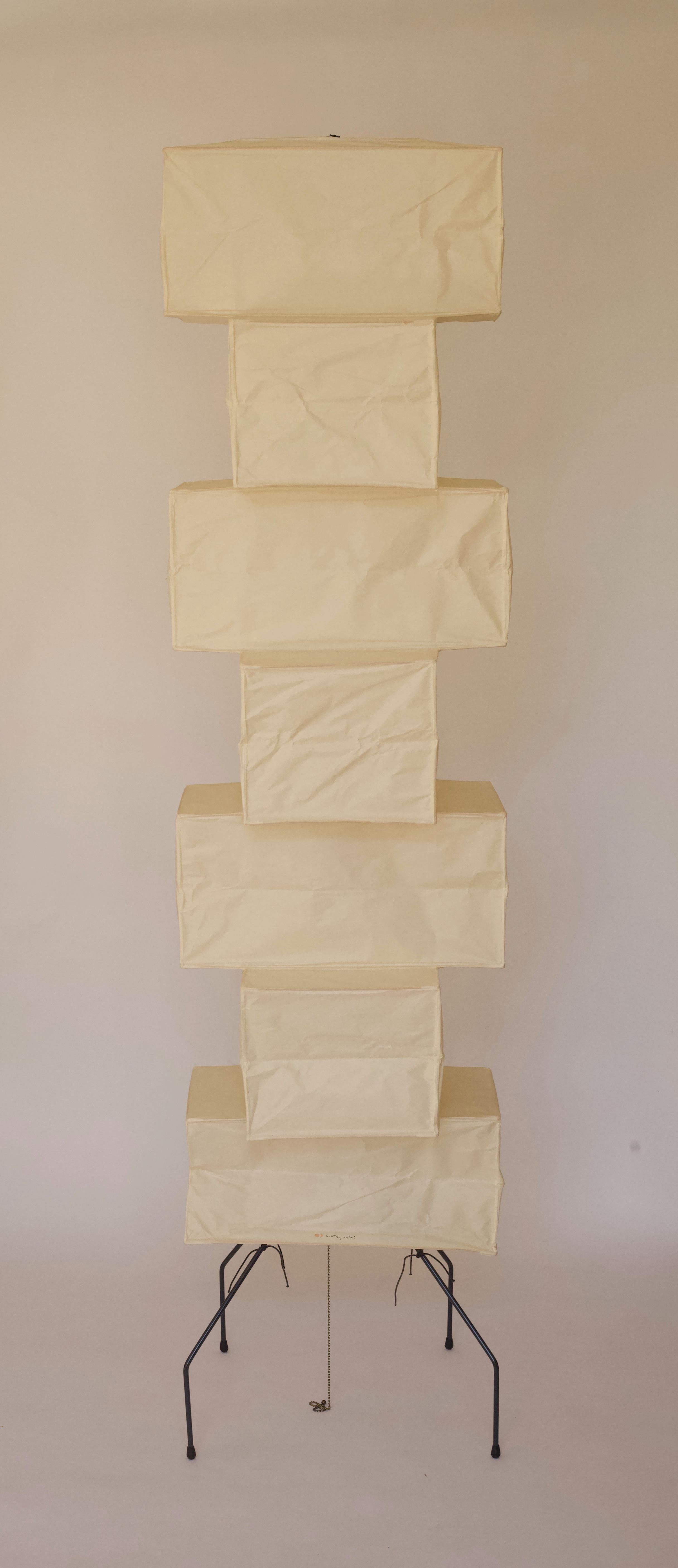A vintage Akari UF4 floor lamp featuring seven vertically layered rectangular forms. The Isamu Noguchi Akari lamps double as a wonderful light source as well as a sculptural conversation piece. The vintage shade has a wonderful, evenly aged patina.
