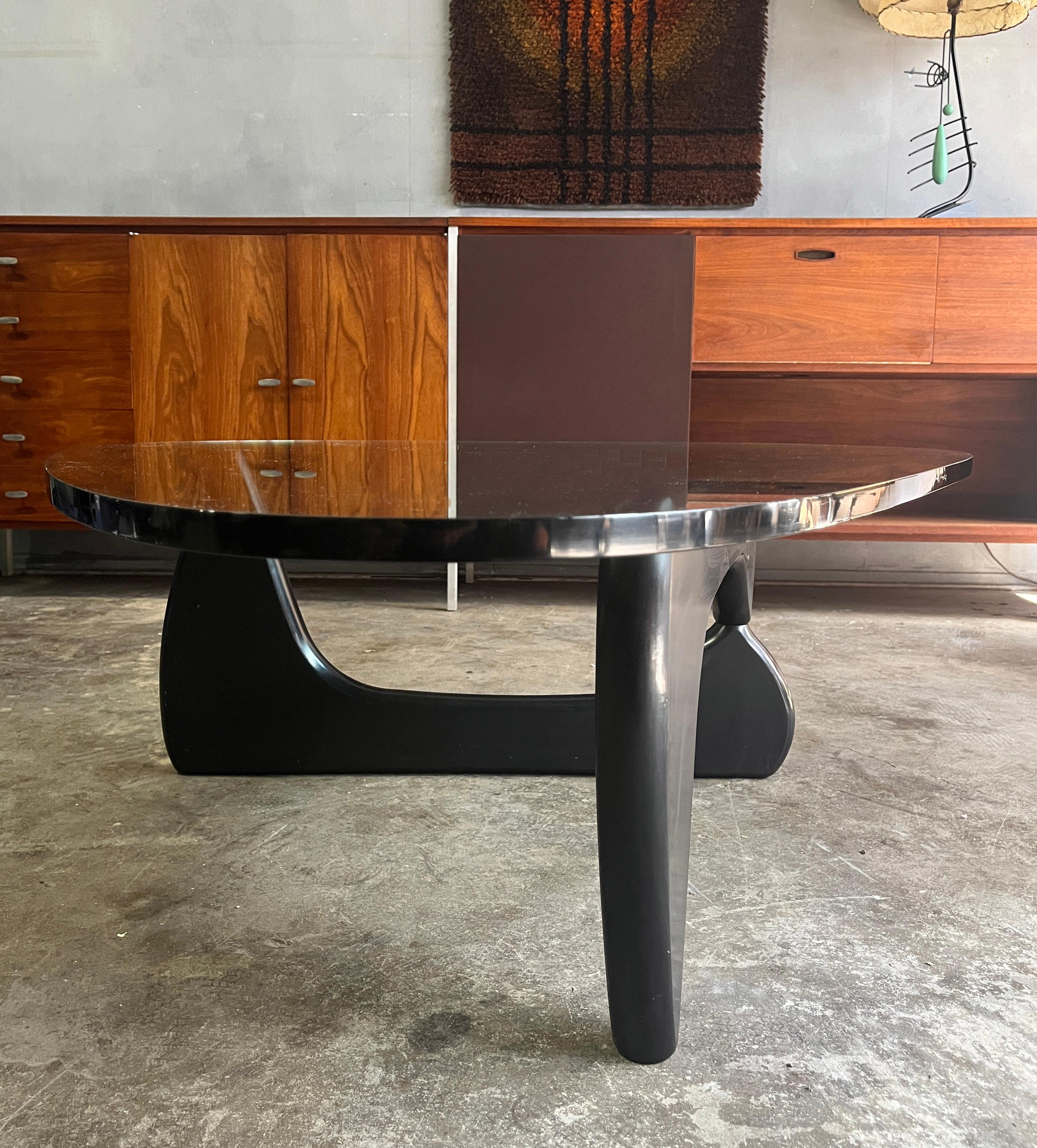 Midcentury Coffee Table IN-50 Designed by Isamu Noguchi for Herman Miller, circa 1940s. An icon in the furniture world. The two curved, wooden shapes that comprise the base are mirror images inverted to provide support to the triangular glass top.